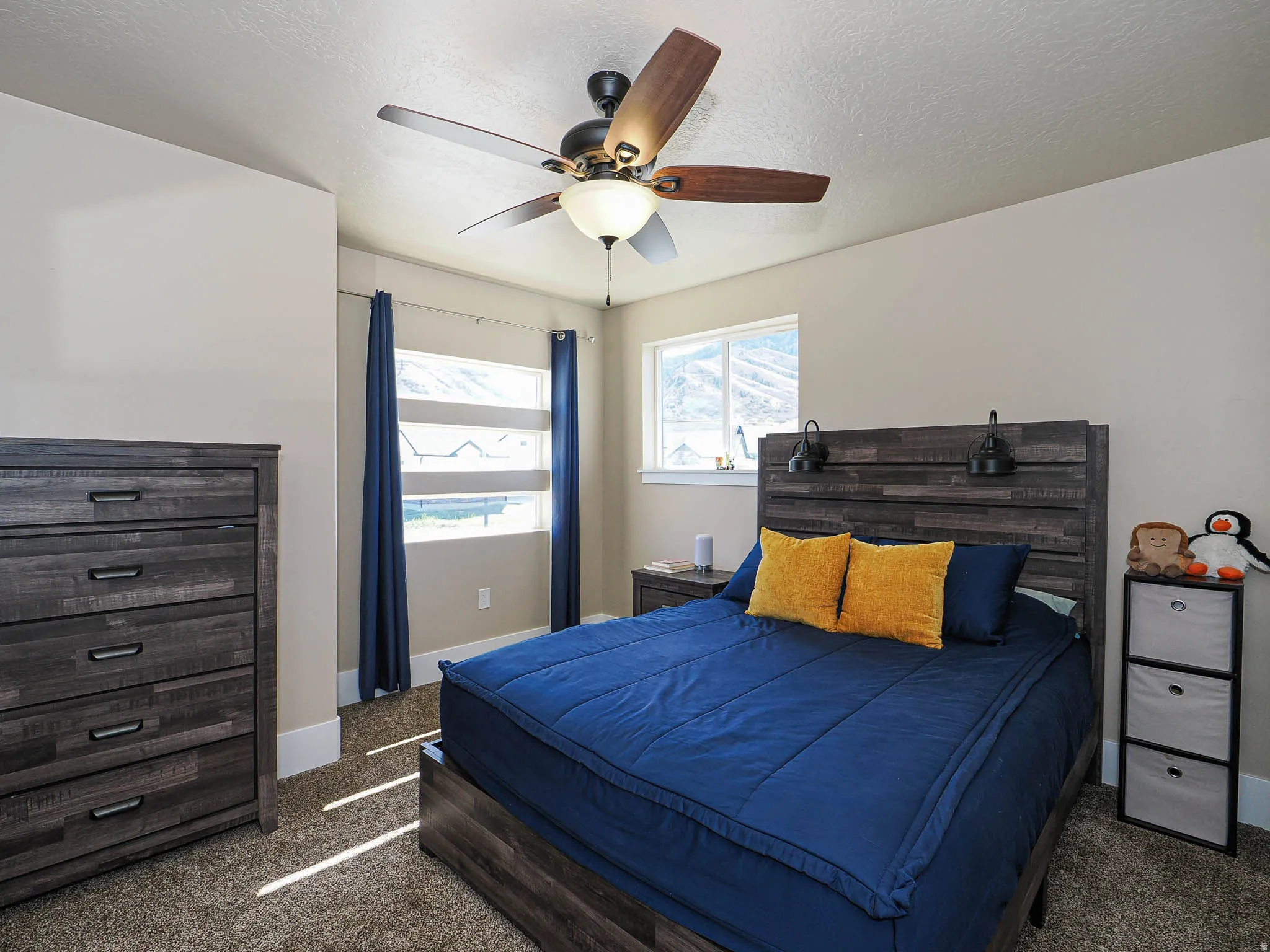Bedroom featuring dark carpet, a textured ceiling, and a ceiling fan