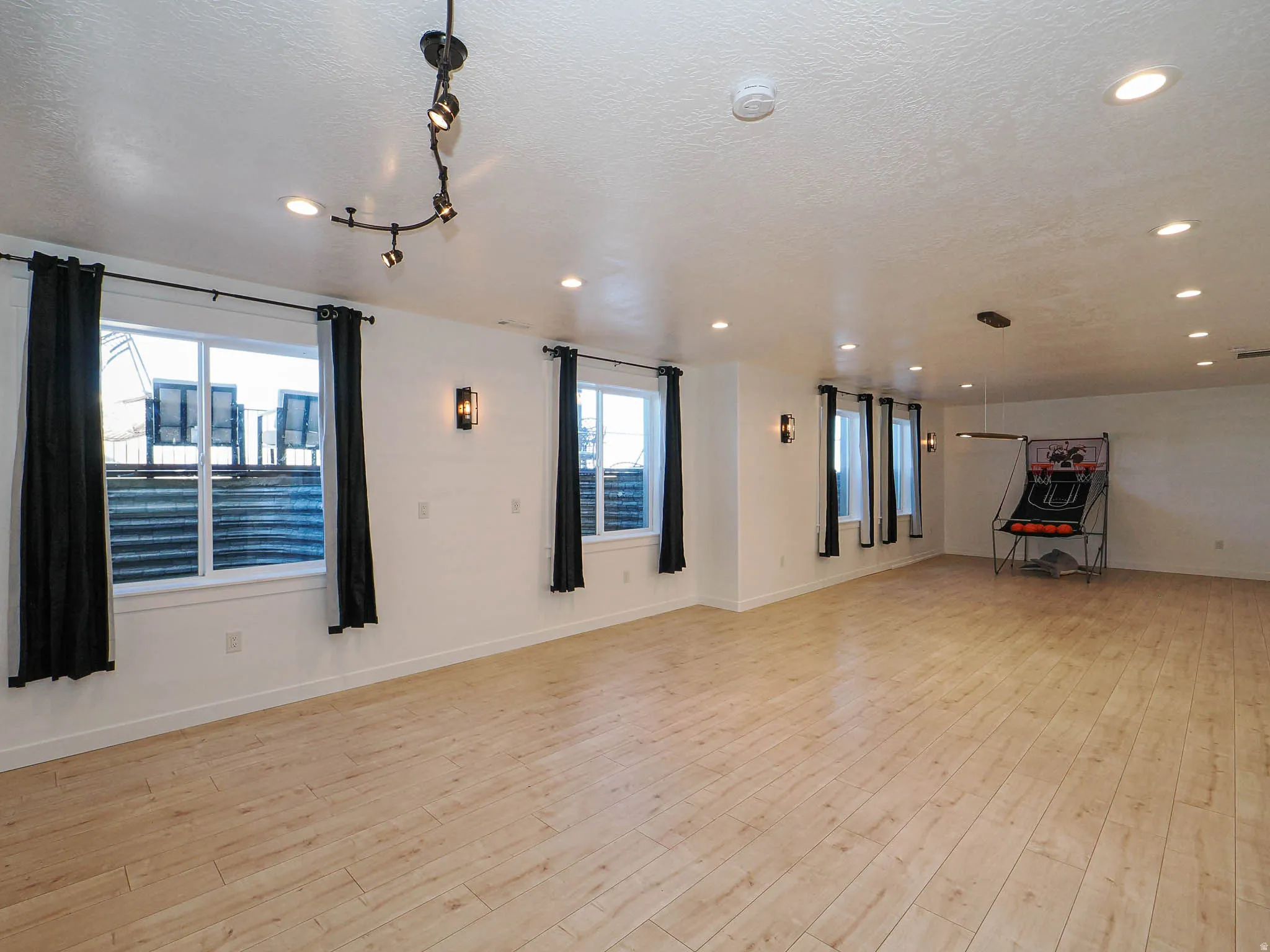 Spare room featuring a textured ceiling, light wood-style flooring, and recessed lighting