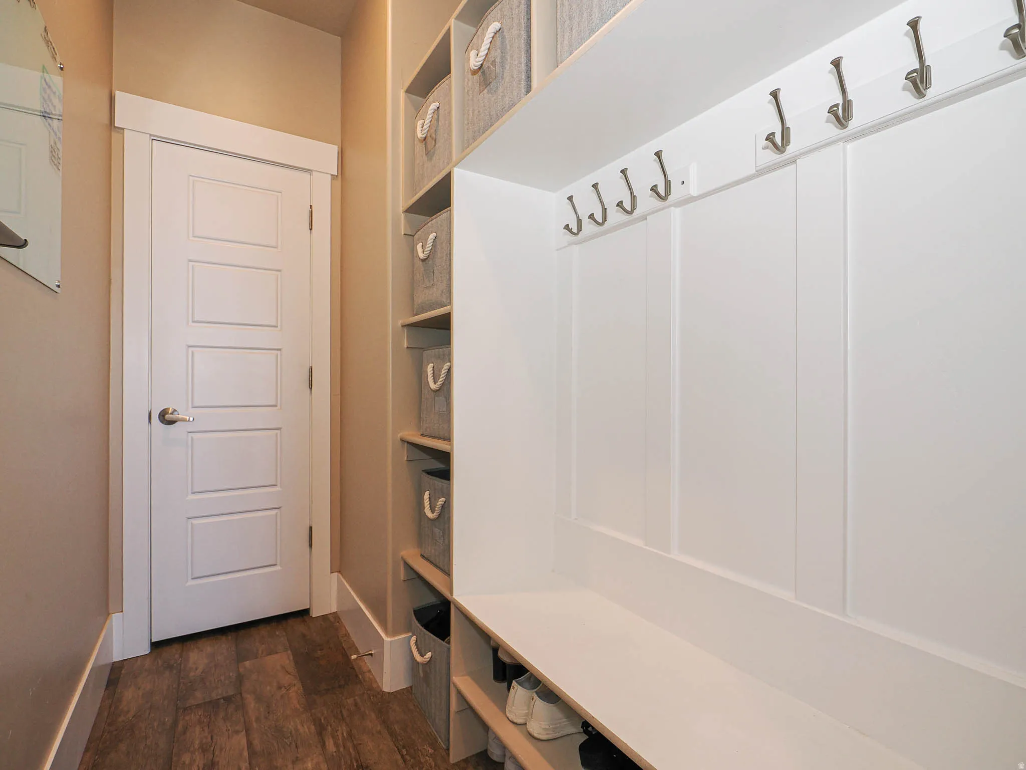 Mudroom with dark wood-type flooring and baseboards