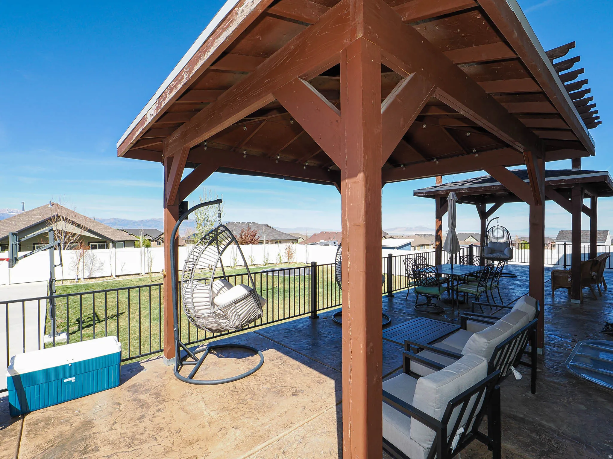 Fenced backyard featuring a patio, outdoor dining space, and a residential view
