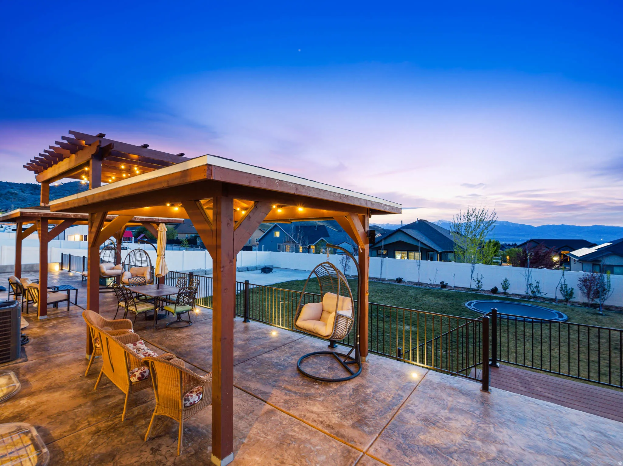 Fenced backyard featuring a patio, outdoor dining space, a gazebo, and a mountain view