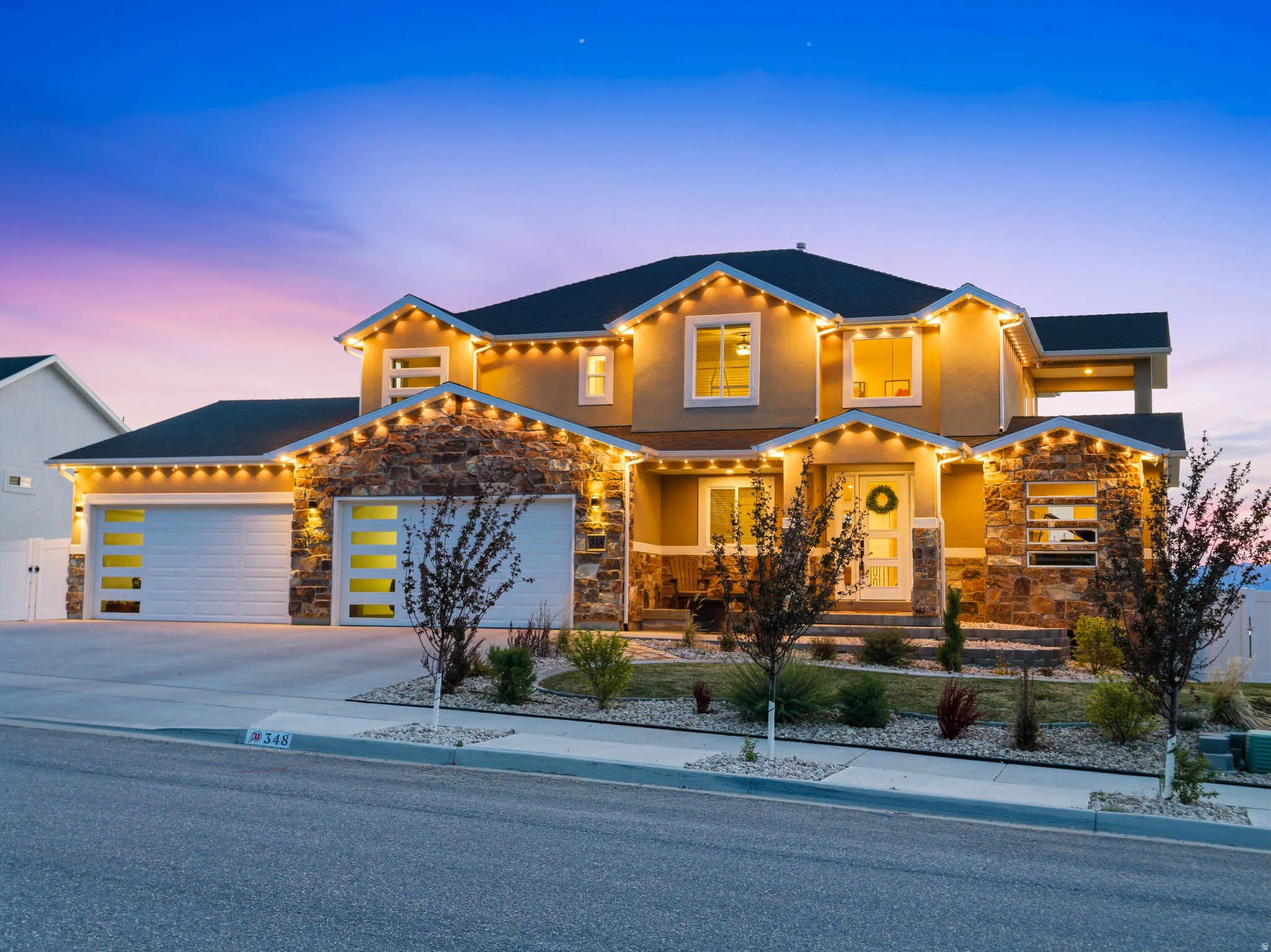 Mediterranean / spanish-style house featuring stone siding, driveway, an attached garage, and stucco siding