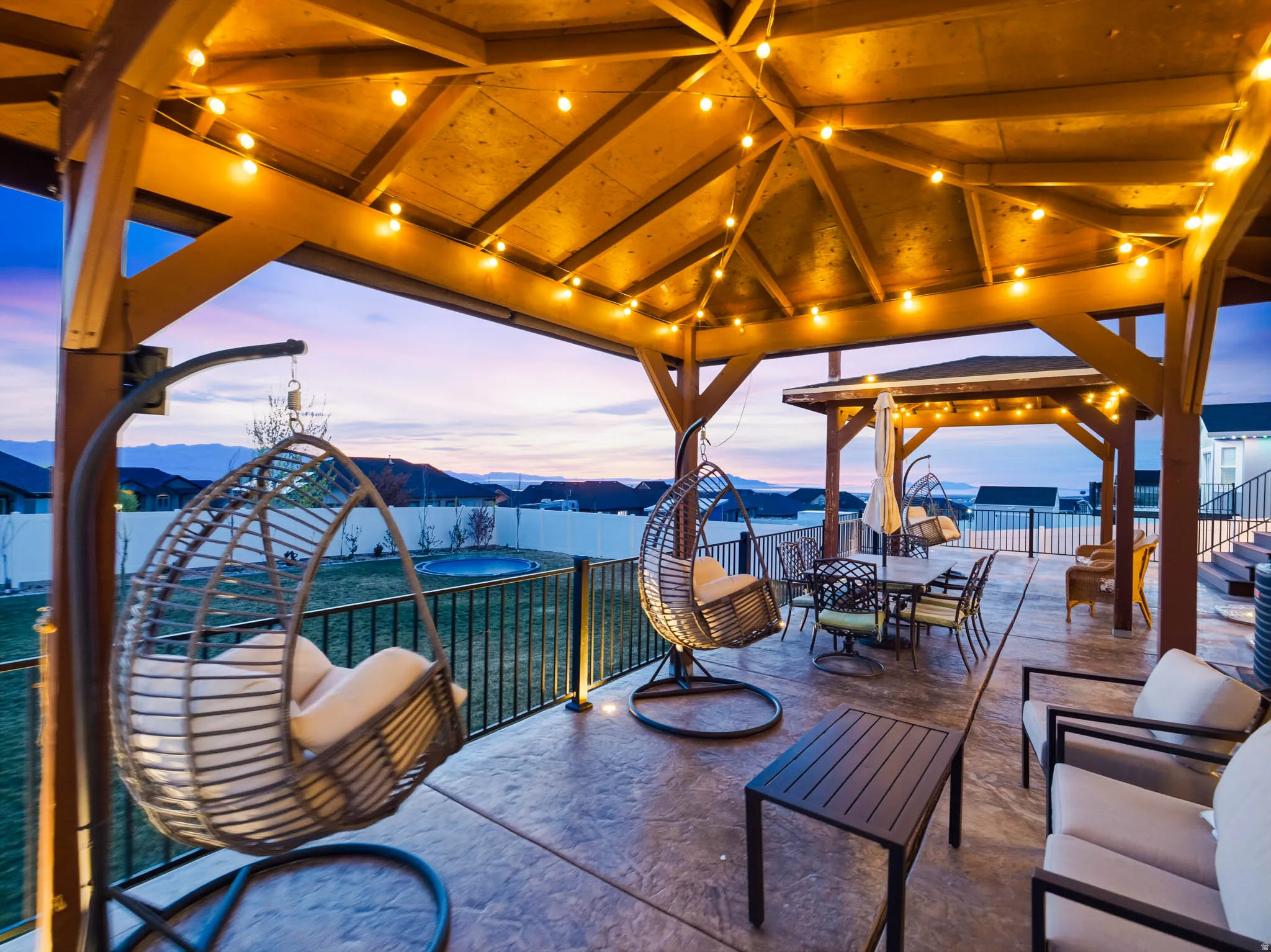 Patio terrace at dusk featuring a mountain view, outdoor dining space, a fenced backyard, and a patio