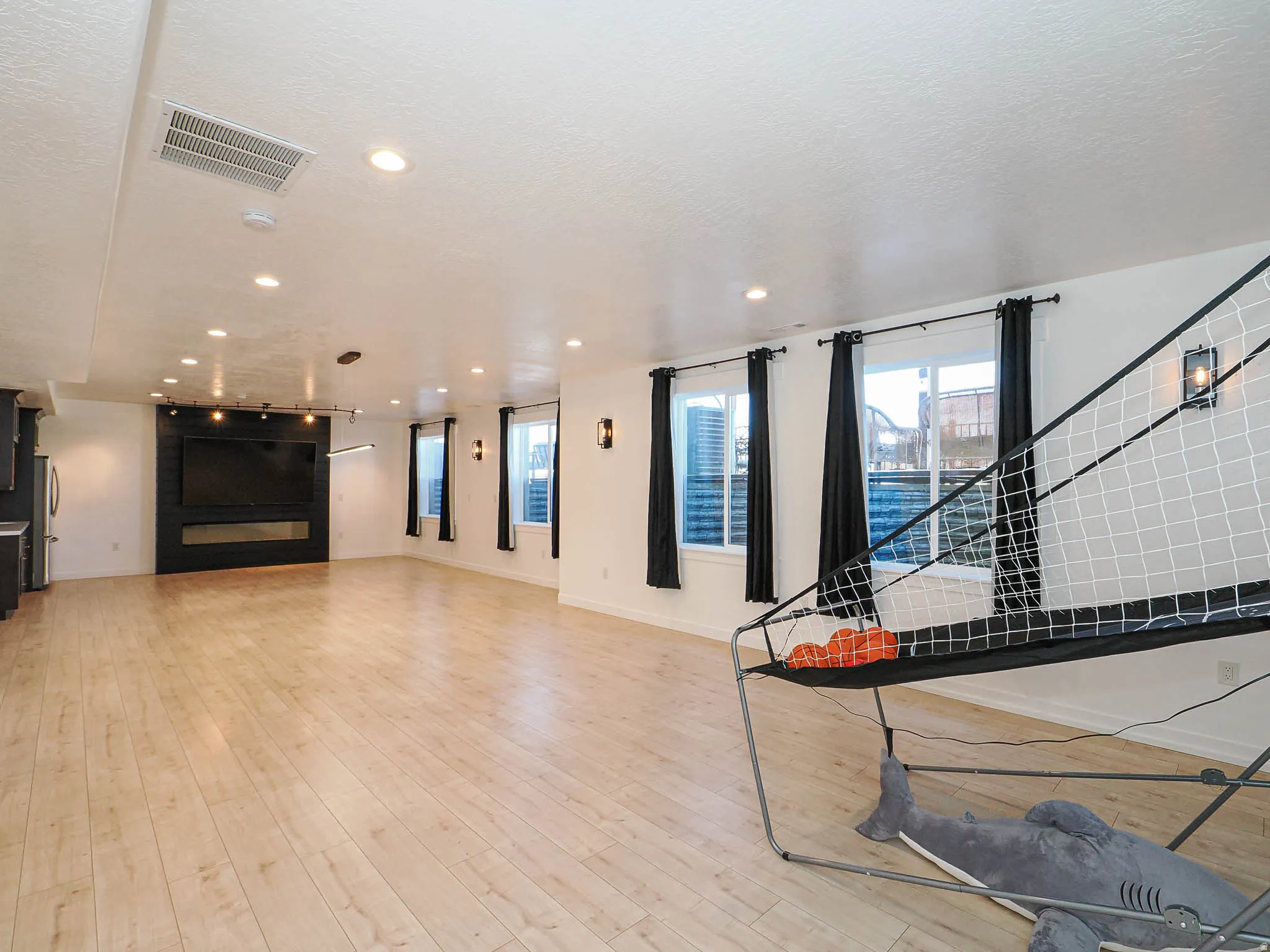 Exercise area with light wood finished floors, recessed lighting, and a textured ceiling