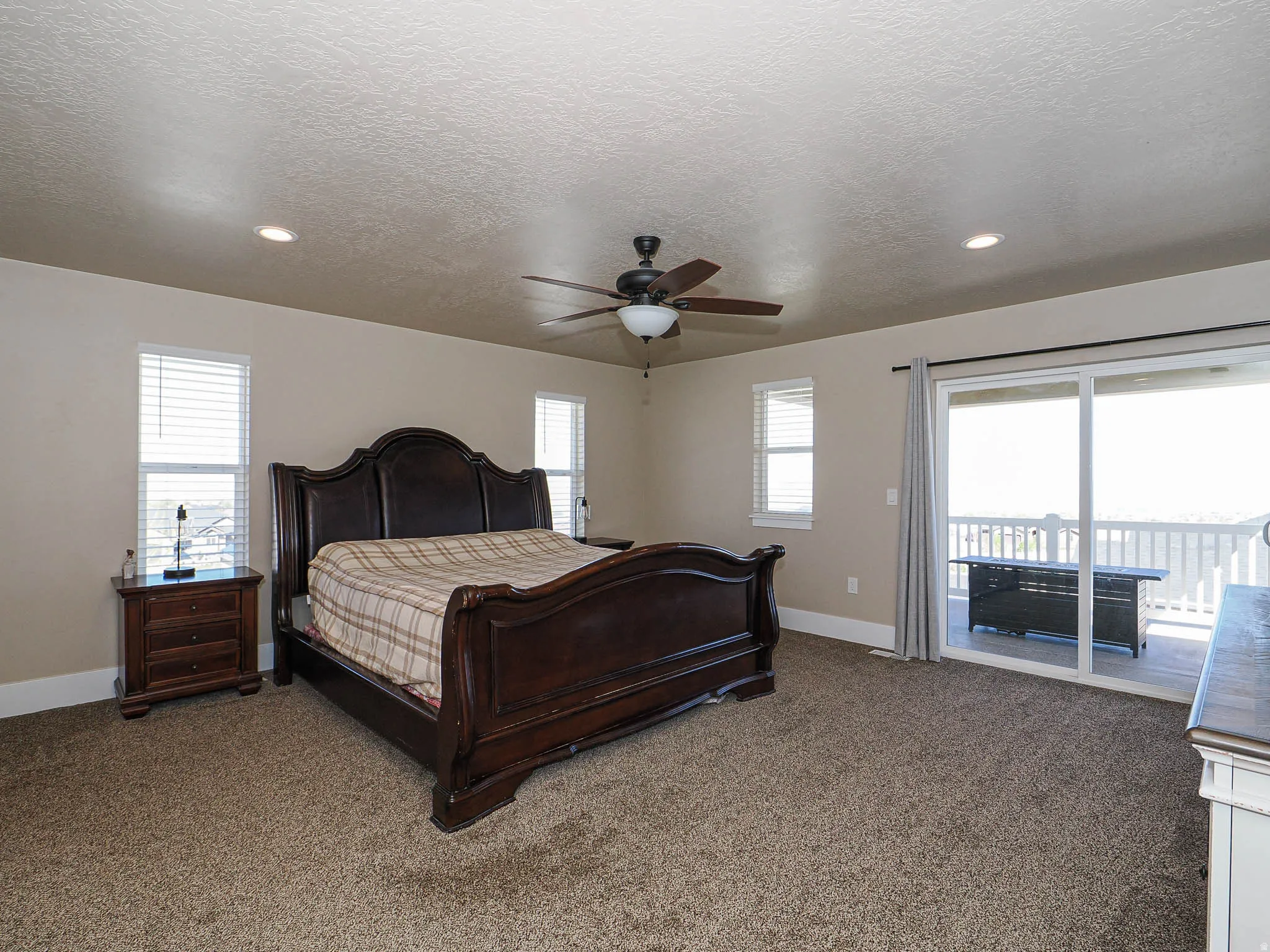 Bedroom featuring ceiling fan, access to outside, recessed lighting, dark carpet, and a textured ceiling