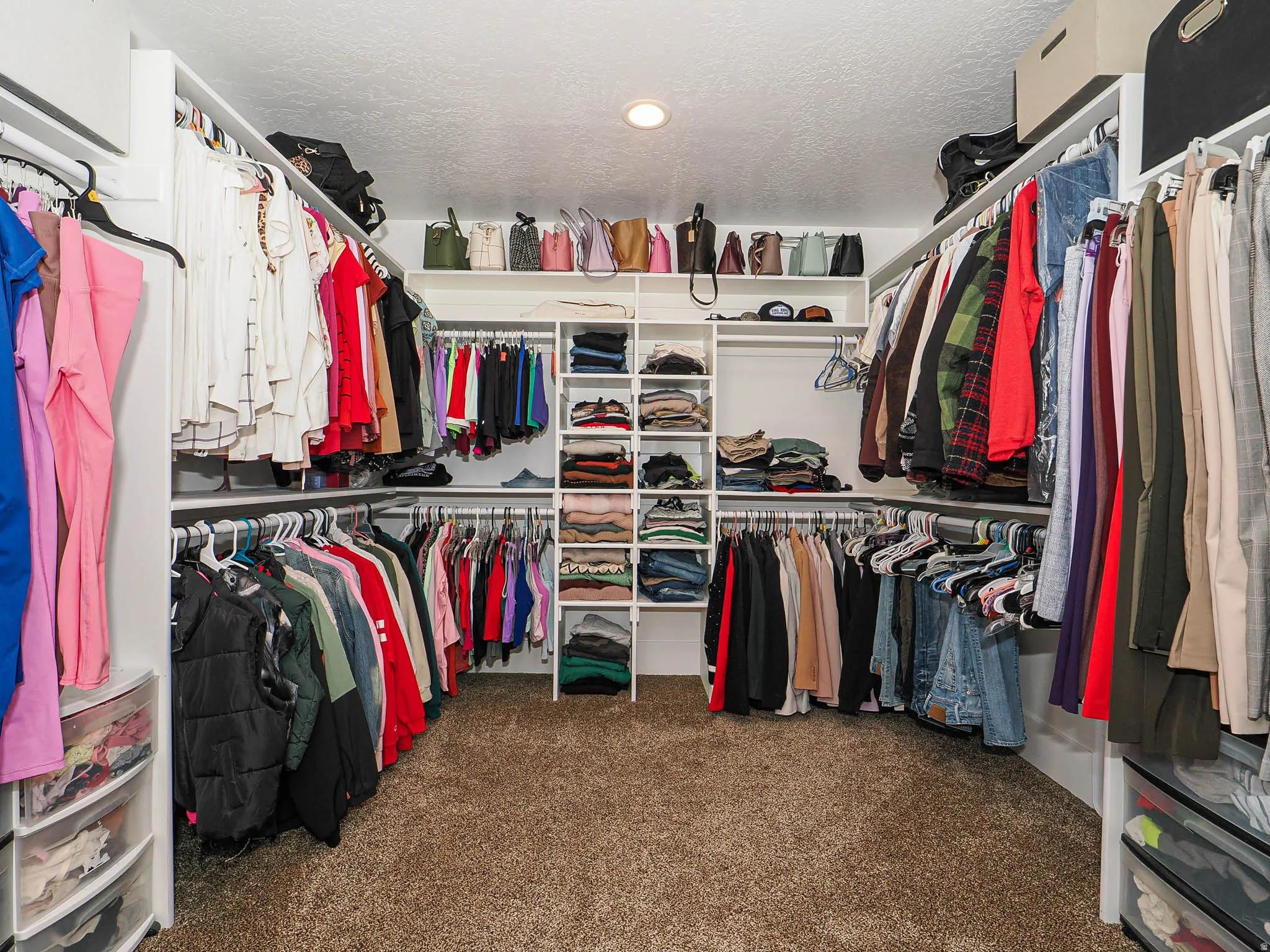 Walk in closet featuring dark colored carpet