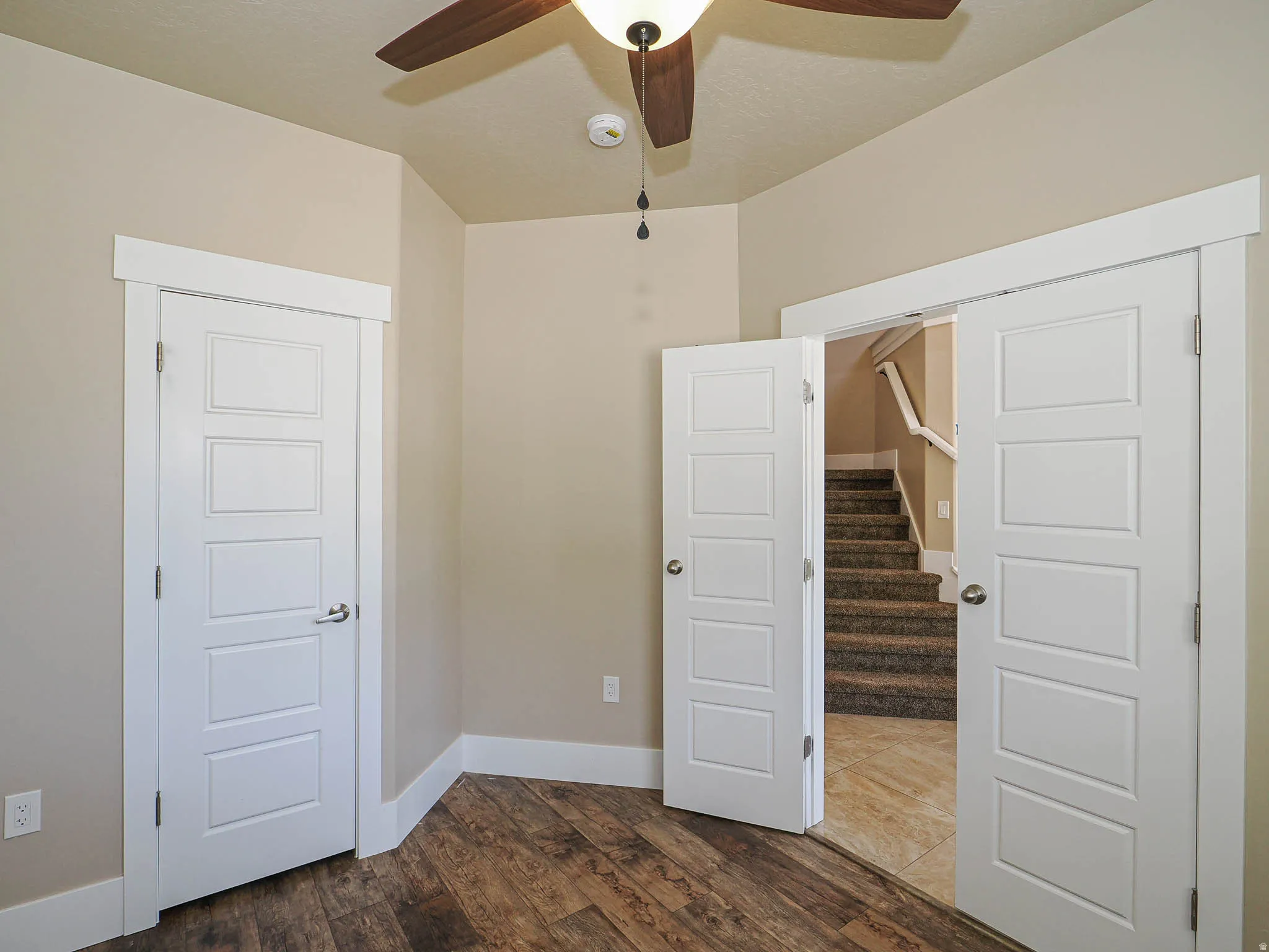 Unfurnished room featuring dark wood-style floors and ceiling fan
