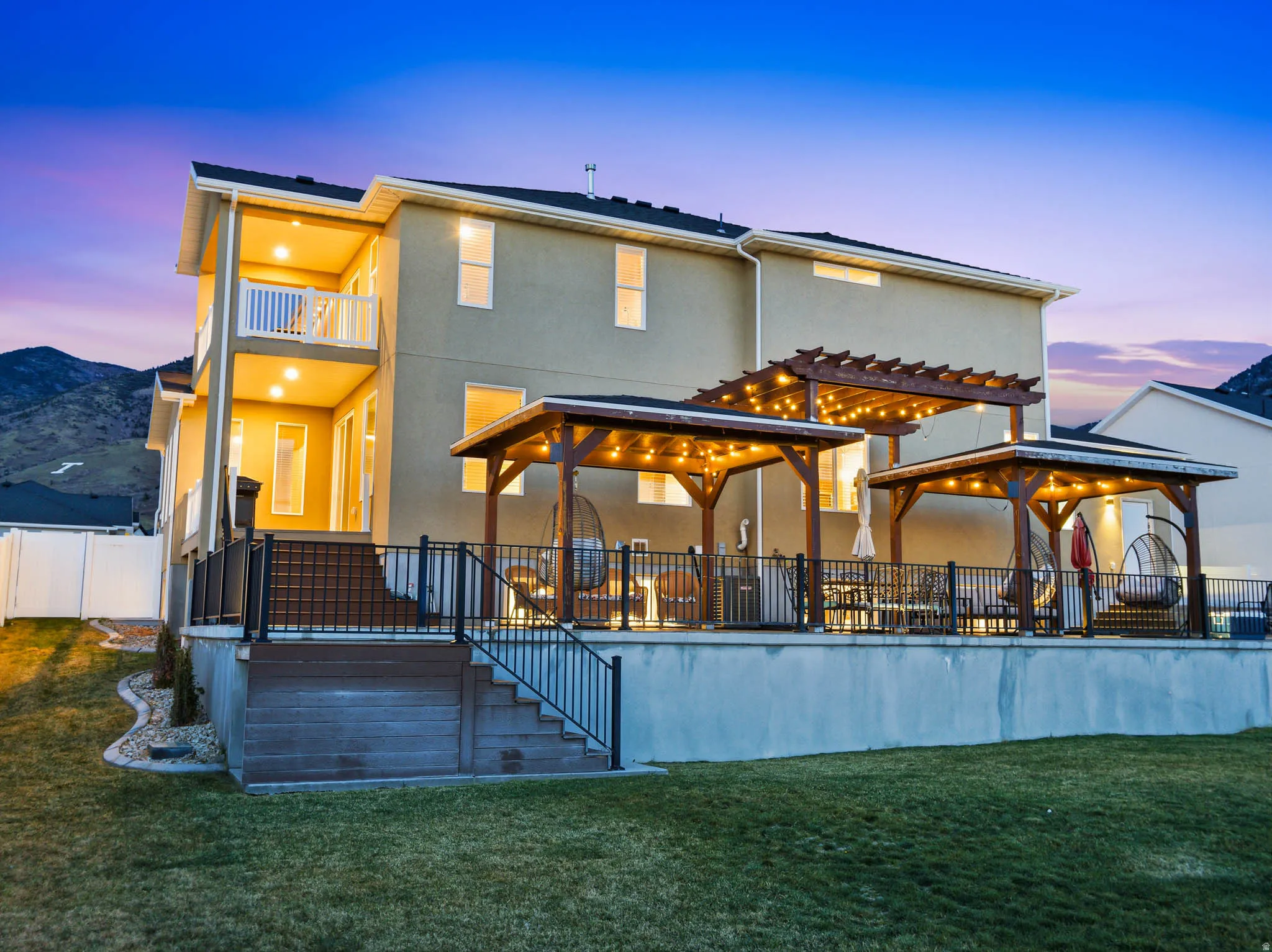 Back of house at dusk featuring stucco siding, a patio, and a pergola