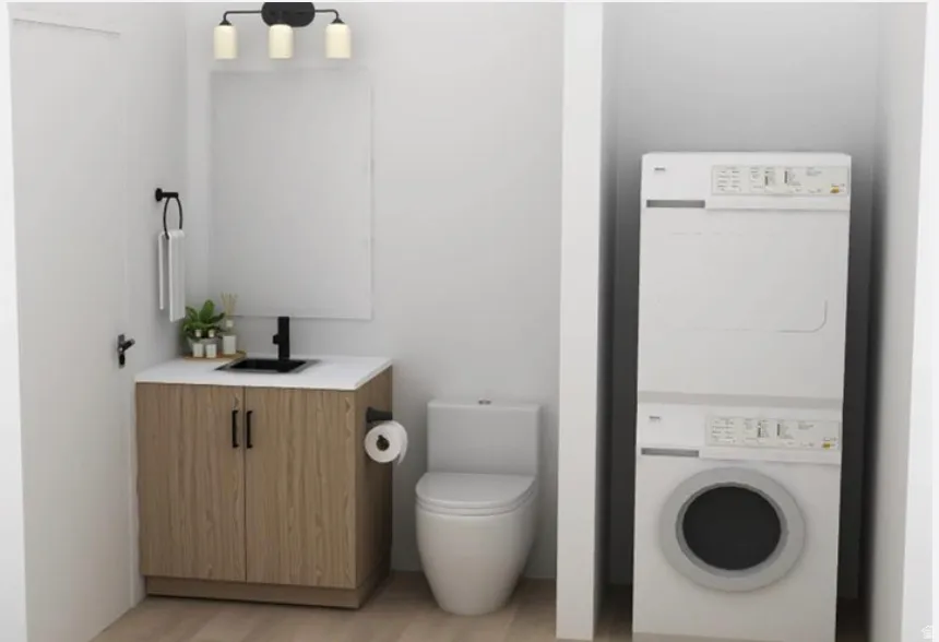 Bathroom with vanity, stacked washer and clothes dryer, and light wood-style flooring