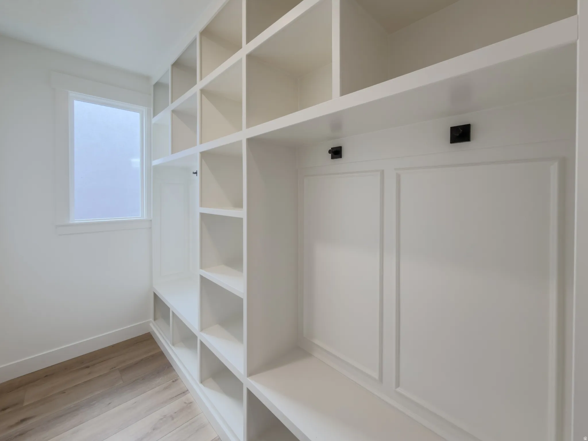 Mudroom featuring light wood-type flooring and baseboards