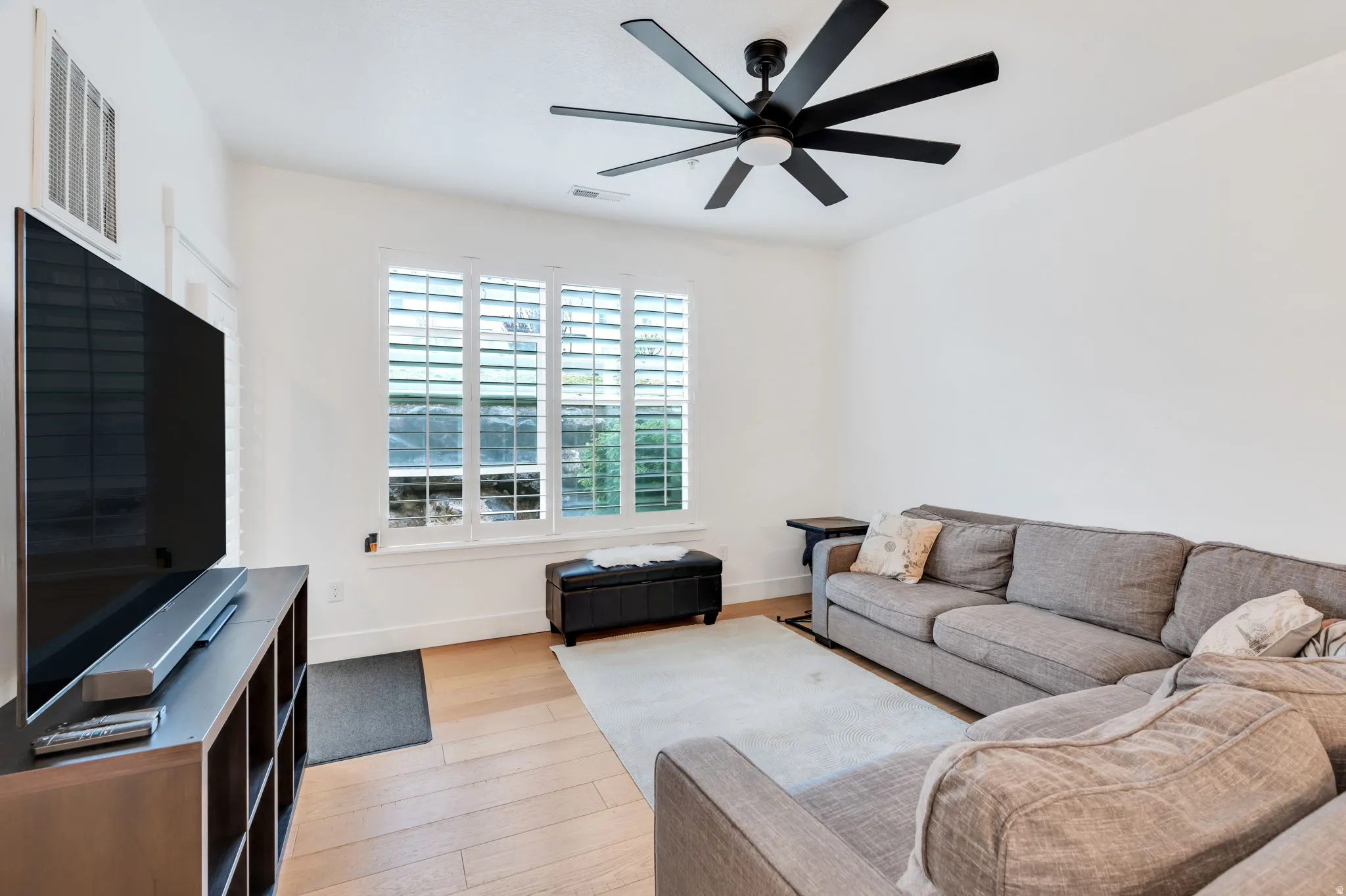 Living room featuring ceiling fan and light wood-style flooring
