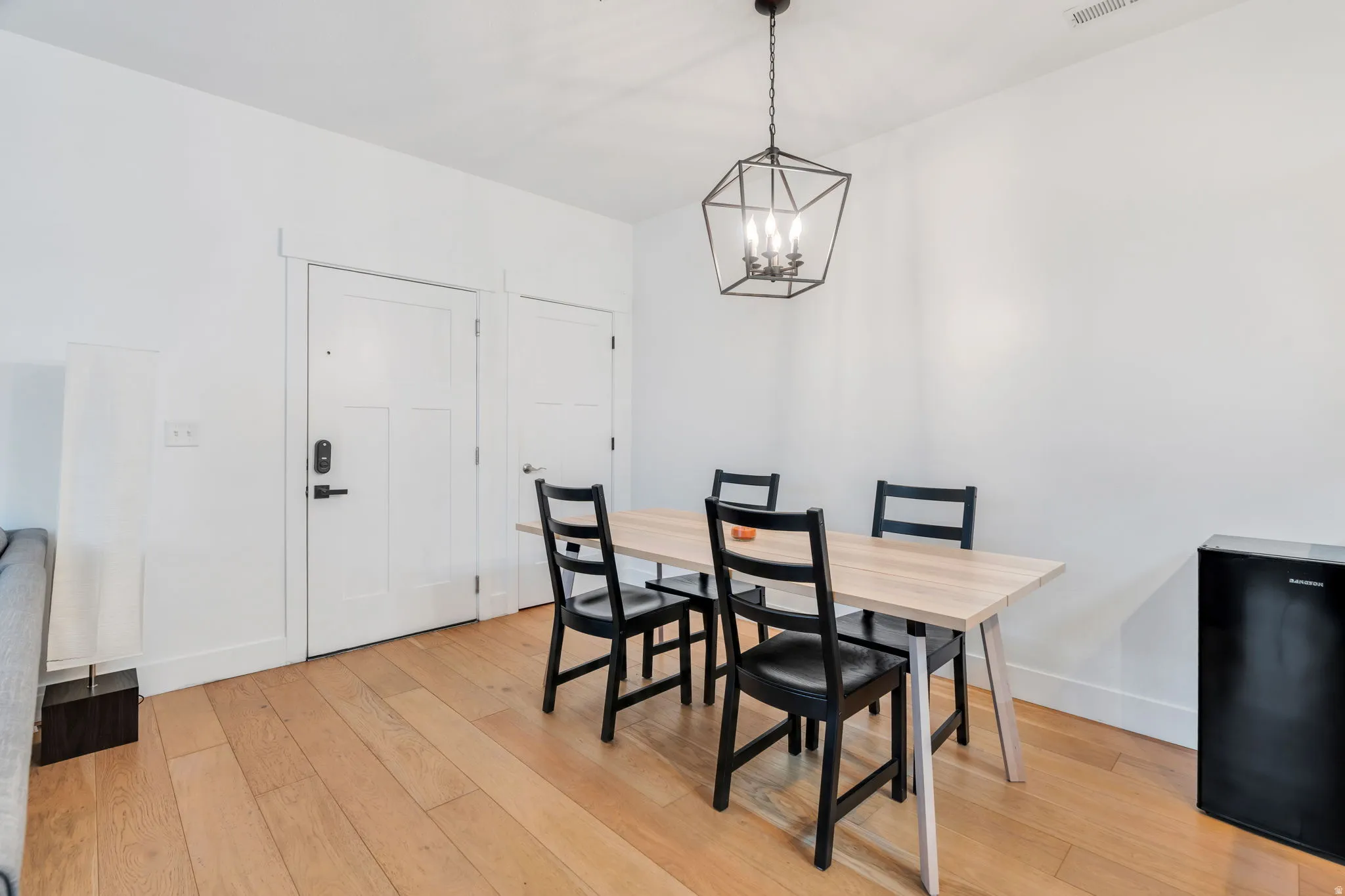 Dining room with light wood-style floors and a chandelier