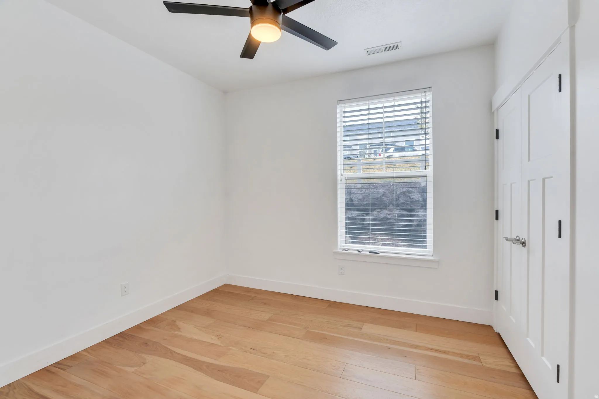 Unfurnished bedroom with light wood-style floors, a ceiling fan, and a closet