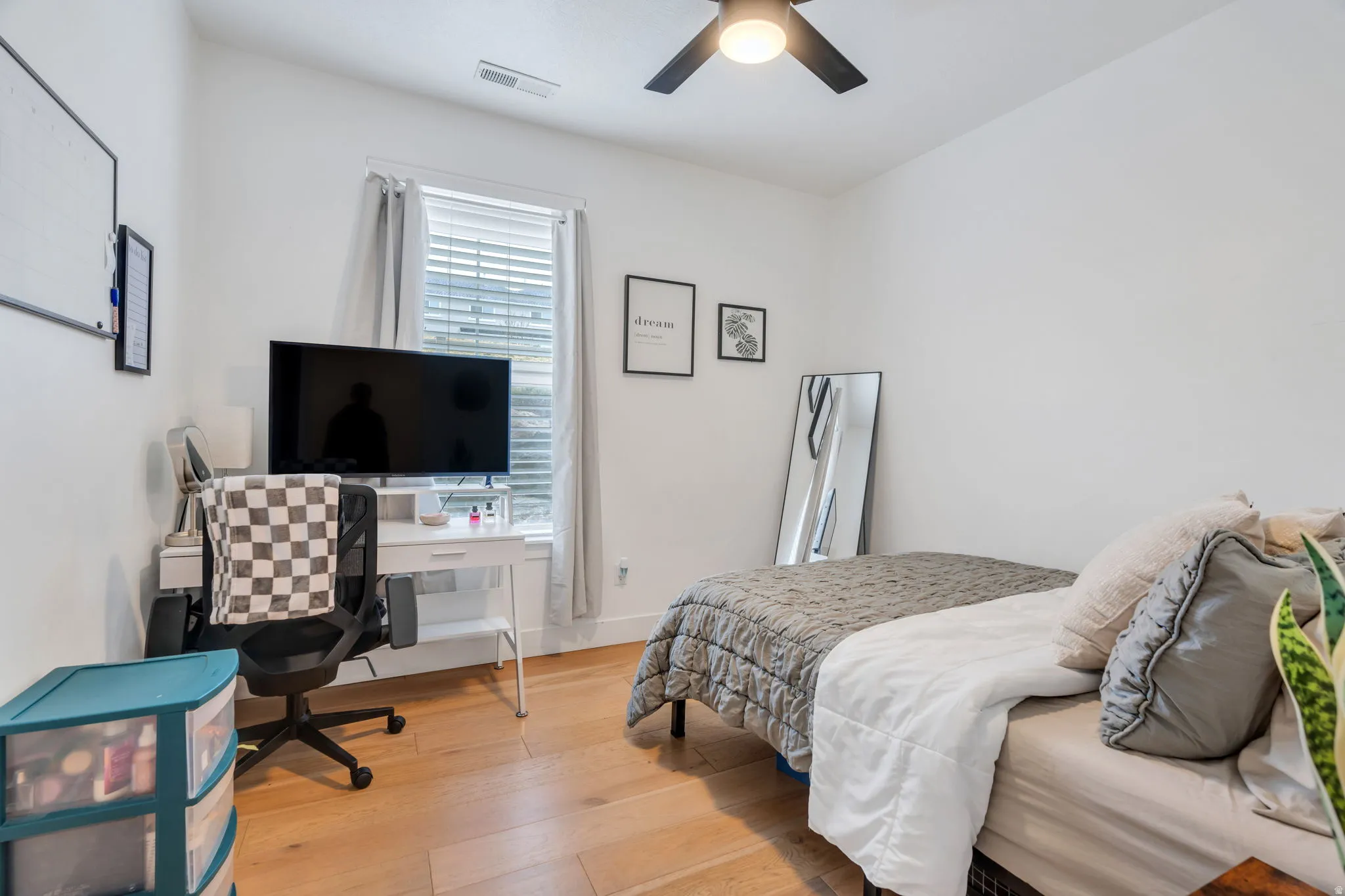 Bedroom featuring light wood finished floors, a desk, and a ceiling fan