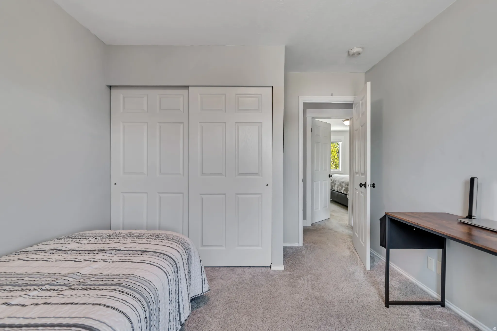Bedroom with light carpet and a closet
