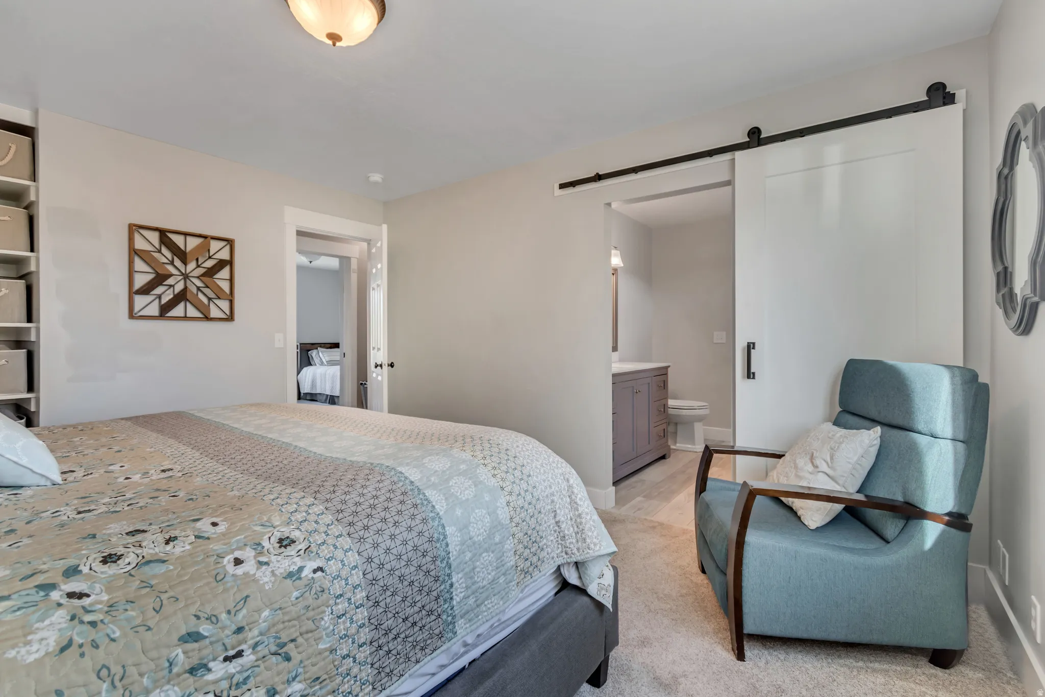 Bedroom featuring a barn door and ensuite bath