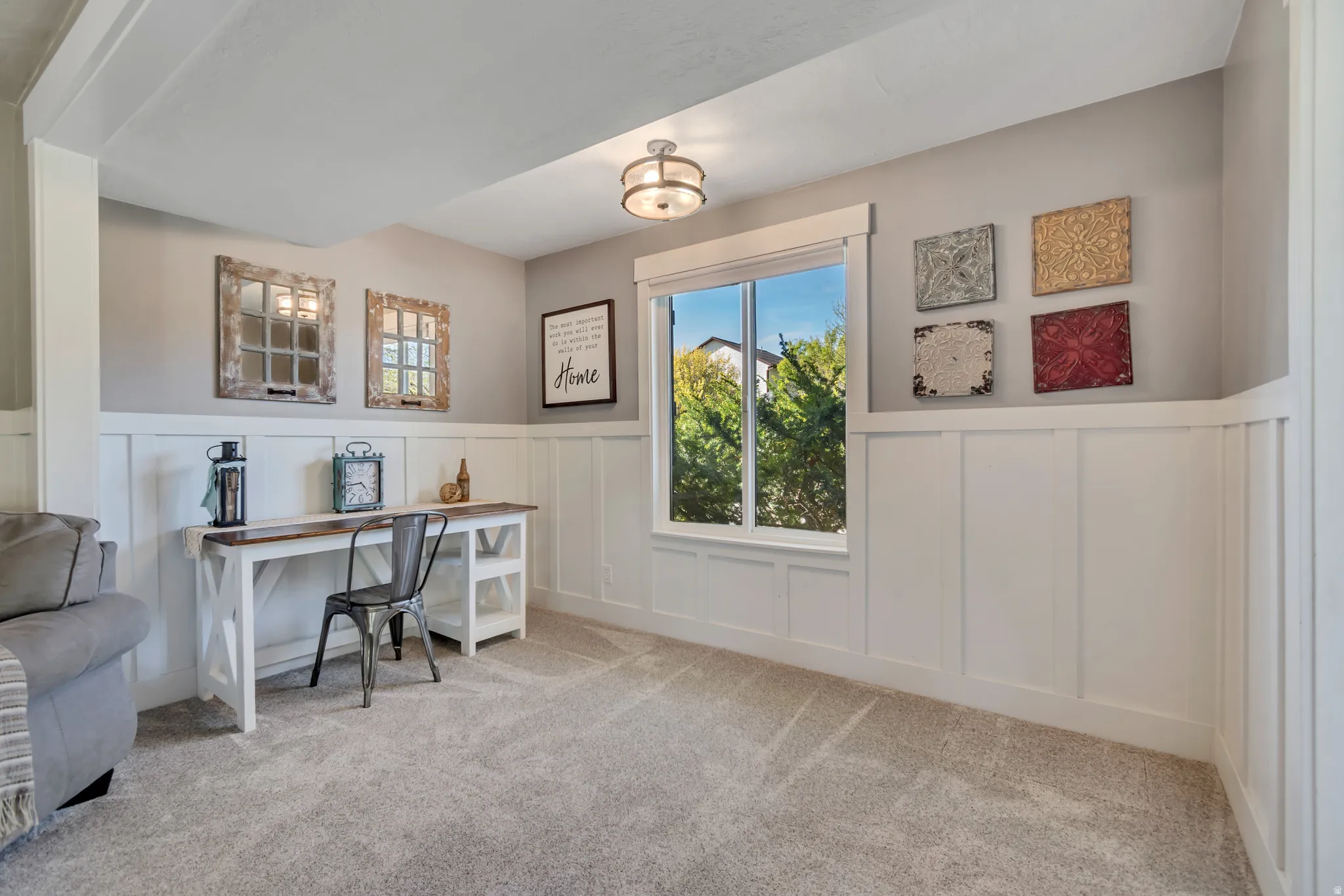 Office area featuring wainscoting, a decorative wall, and light colored carpet