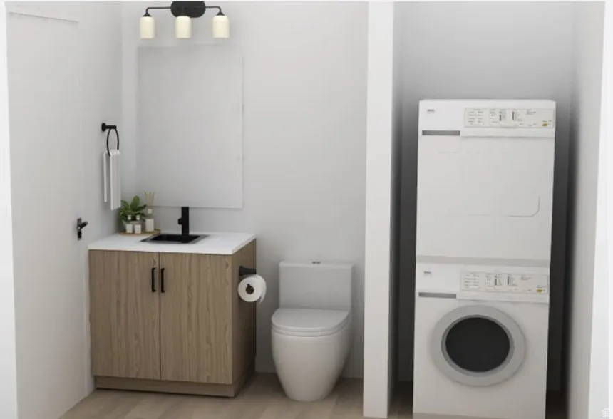 Bathroom with vanity, stacked washer and clothes dryer, and light wood-style floors