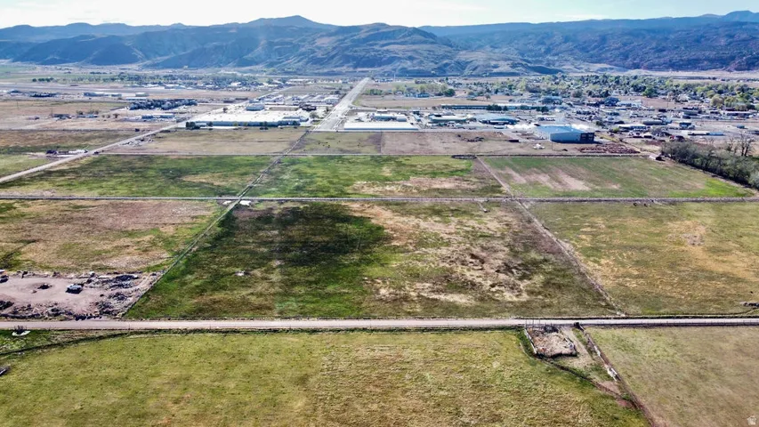 Aerial view of property and surrounding area with a mountainous background and rural landscape