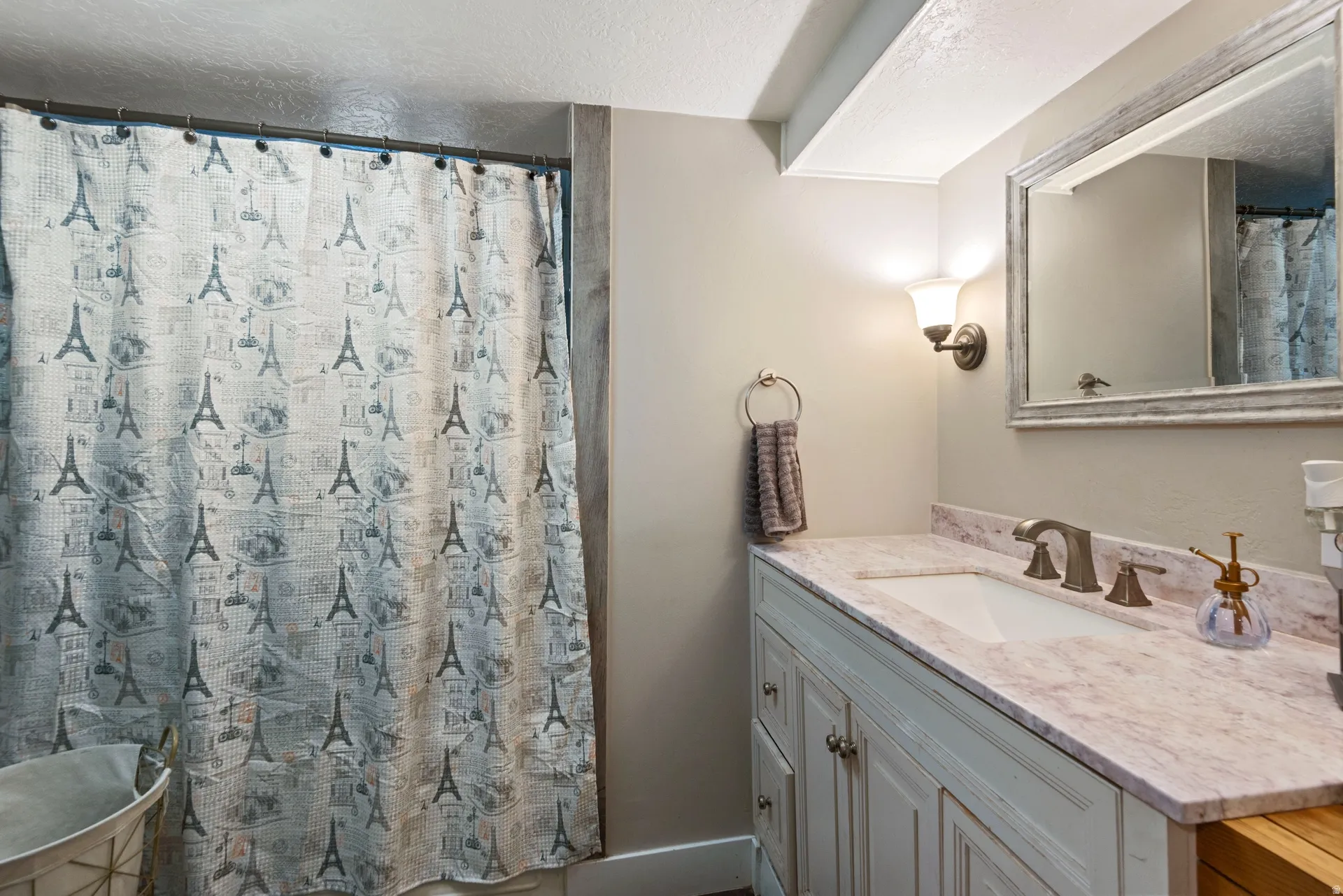 Full bath with vanity, a textured ceiling, and a shower with curtain