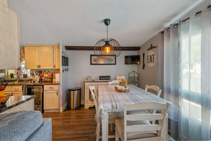 Dining area with wine cooler and dark wood-style floors