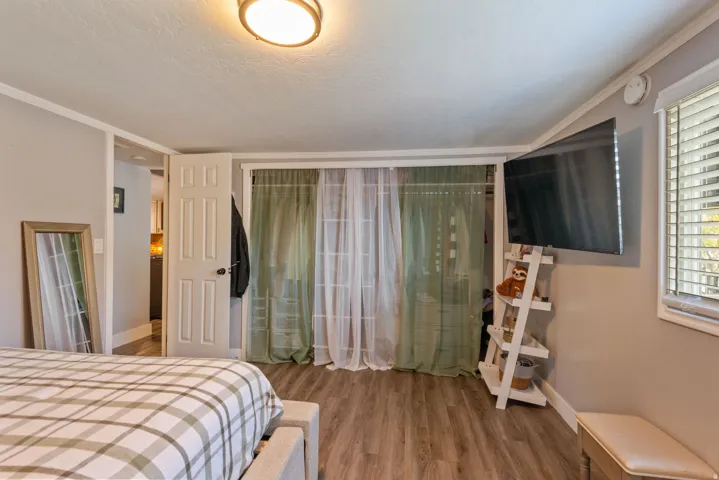 Bedroom featuring a closet, light wood-type flooring, and crown molding