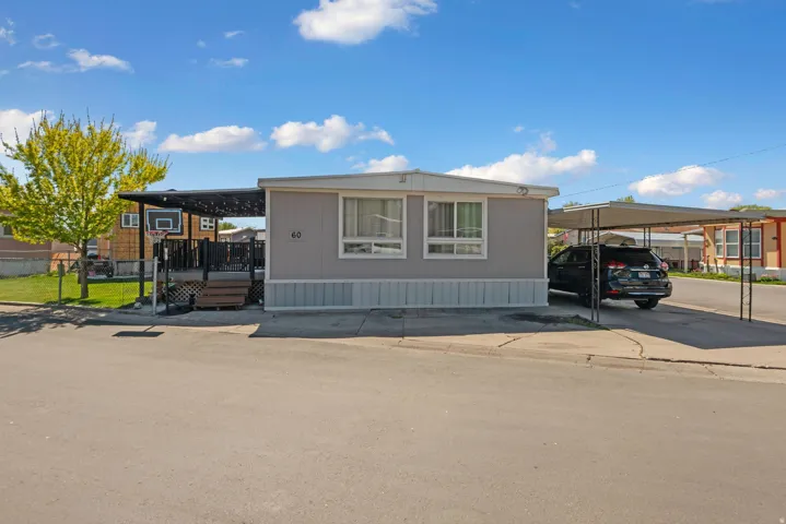 Manufactured / mobile home with a wooden deck and a carport