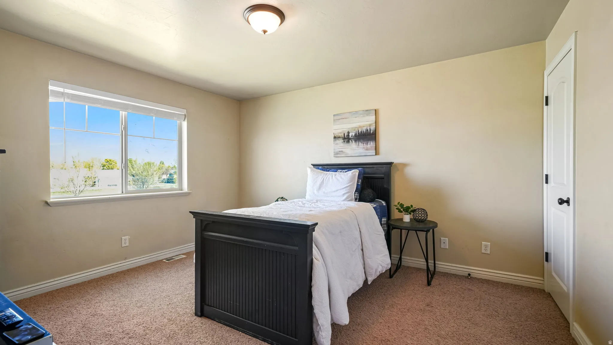 Bedroom featuring light carpet and baseboards