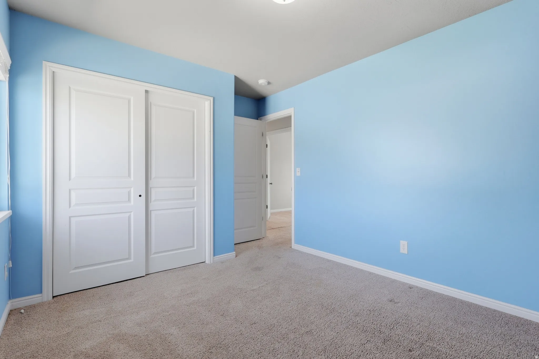 Unfurnished bedroom featuring a closet and light carpet