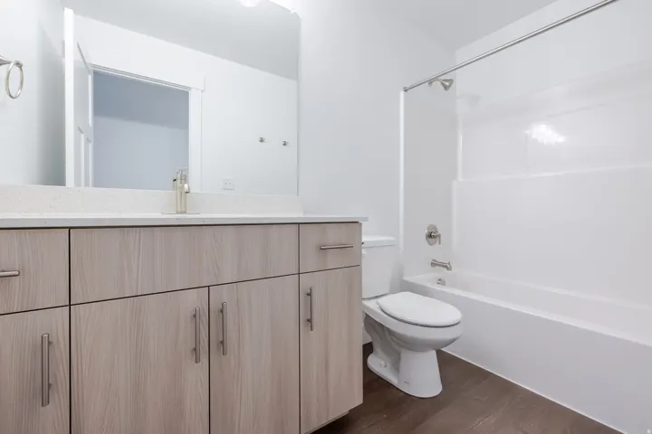 Wood-finish vanity with a light-toned countertop, integrated sink, and brushed nickel faucet