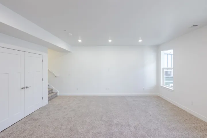 Recessed lighting, white walls, light-toned carpeting, white trim, and a double-hung window