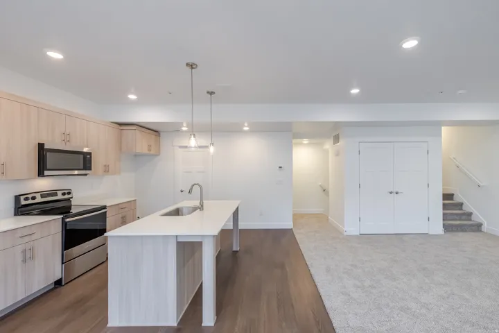 Kitchen featuring wood-finish cabinetry, stainless steel appliances, and a central island with a sink