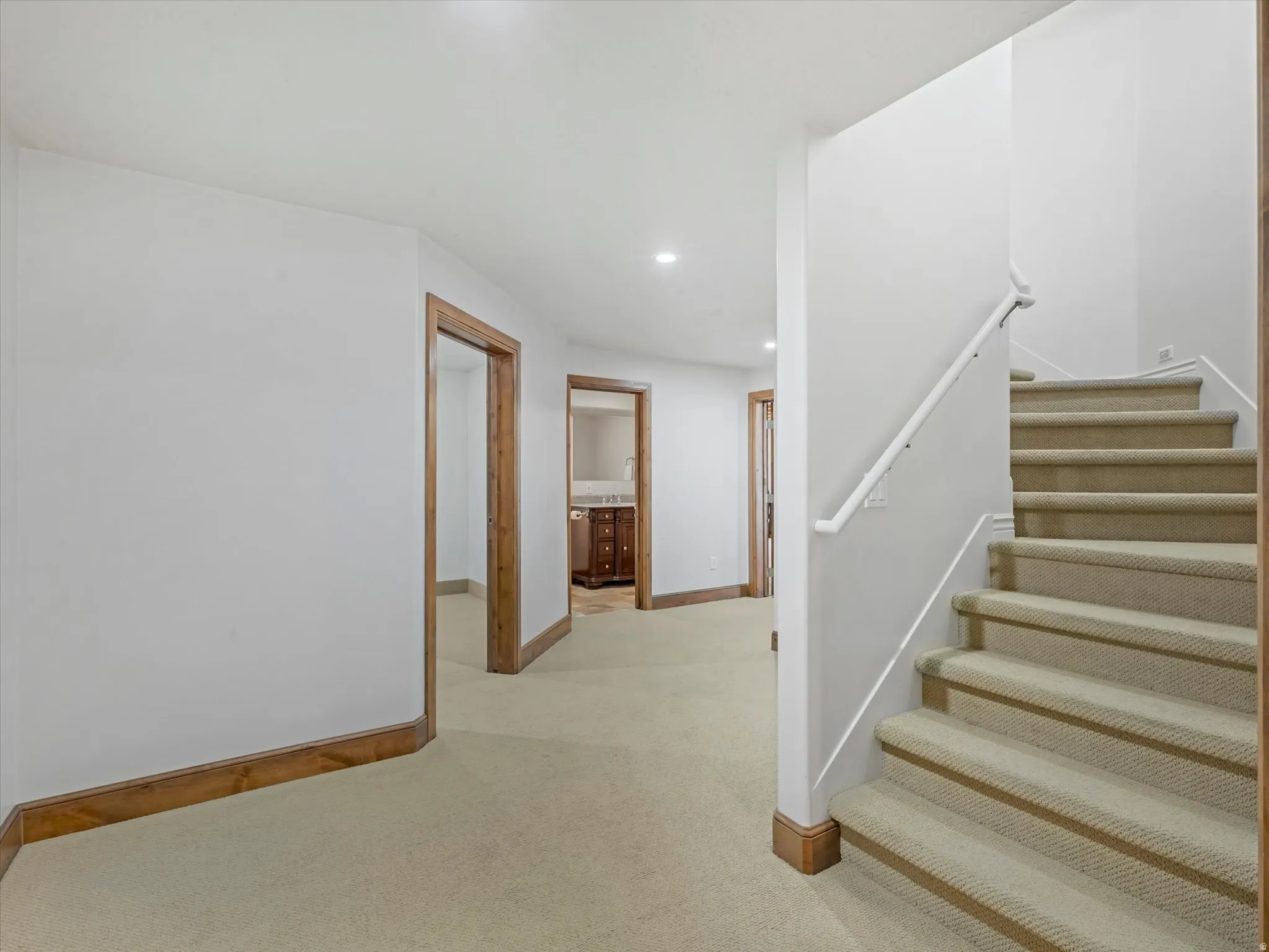 Stairway with recessed lighting and carpet flooring
