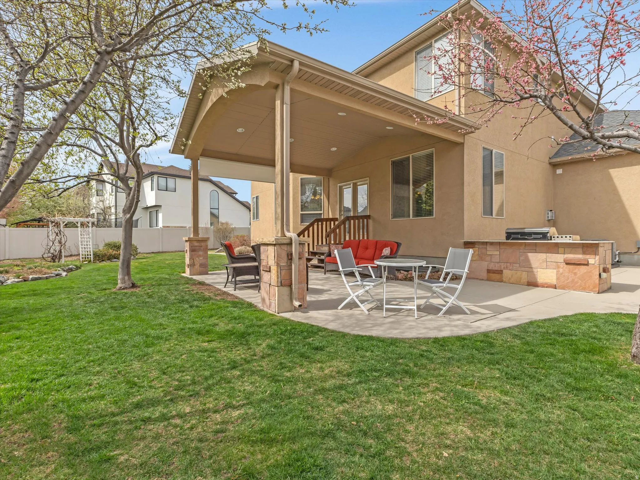 Back of house featuring a patio area, exterior kitchen, and stucco siding