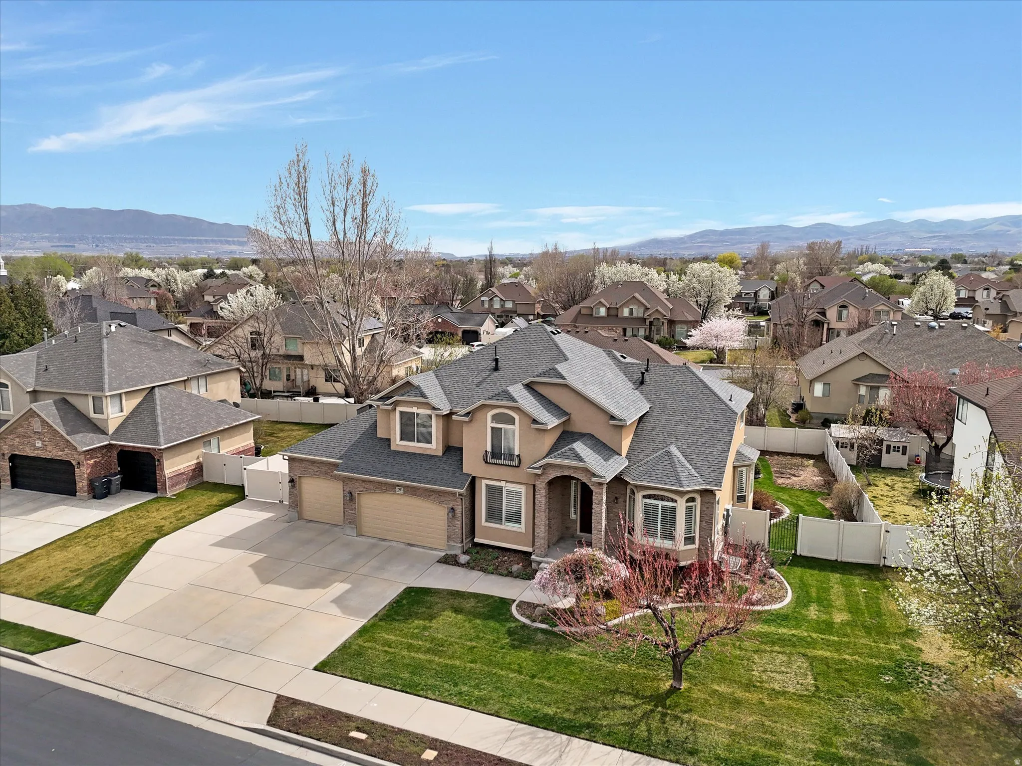 View of front of home featuring a shingled roof, a gate, a residential view, driveway, and a mountain view