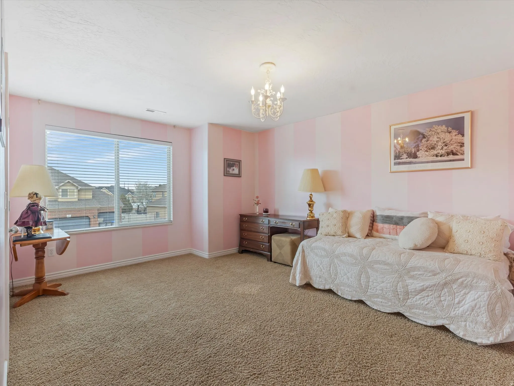 Bedroom featuring light colored carpet and suspended lighting