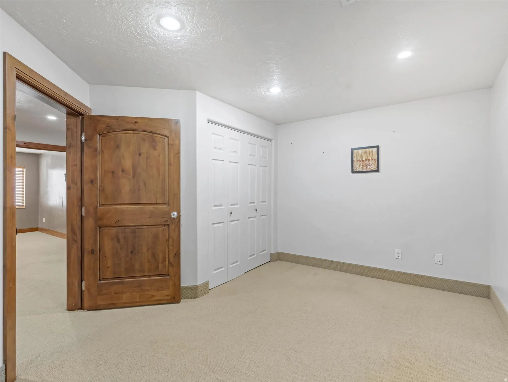 Unfurnished bedroom featuring light carpet, a closet, and recessed lighting
