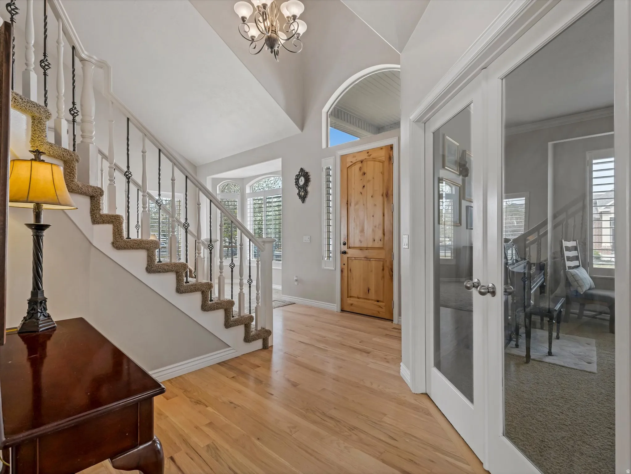 Foyer with light wood finished floors and a chandelier