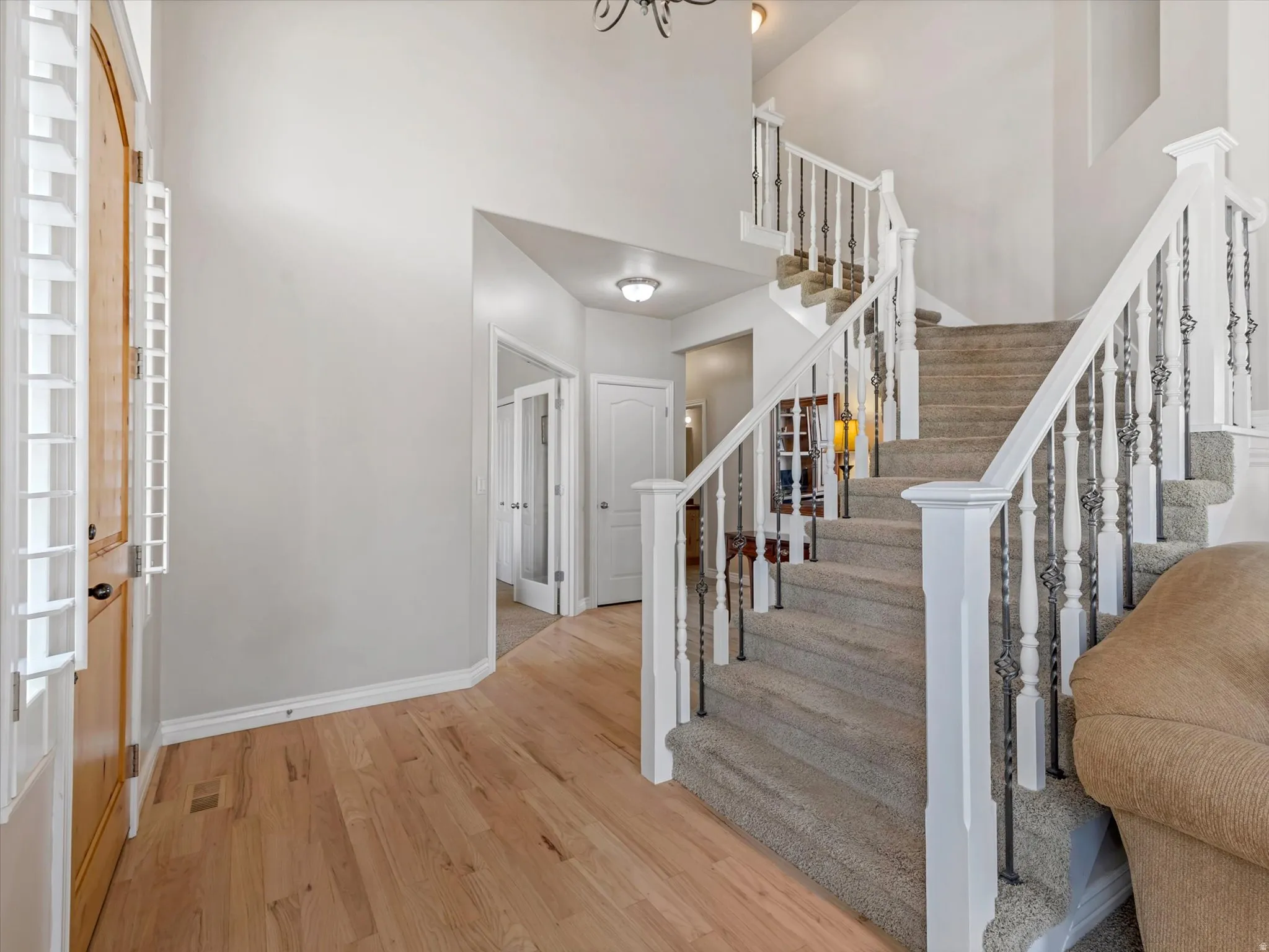 Entrance foyer with light wood-type flooring and a high ceiling