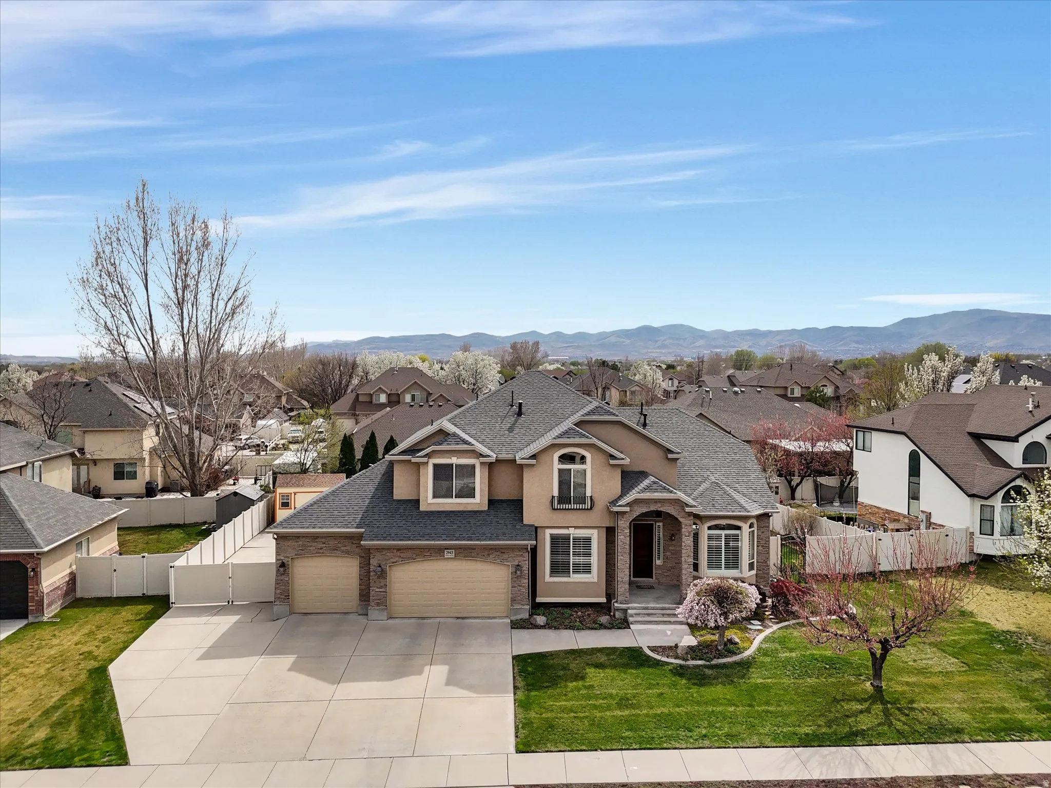 Traditional-style house with roof with shingles, a residential view, a gate, concrete driveway, and a garage