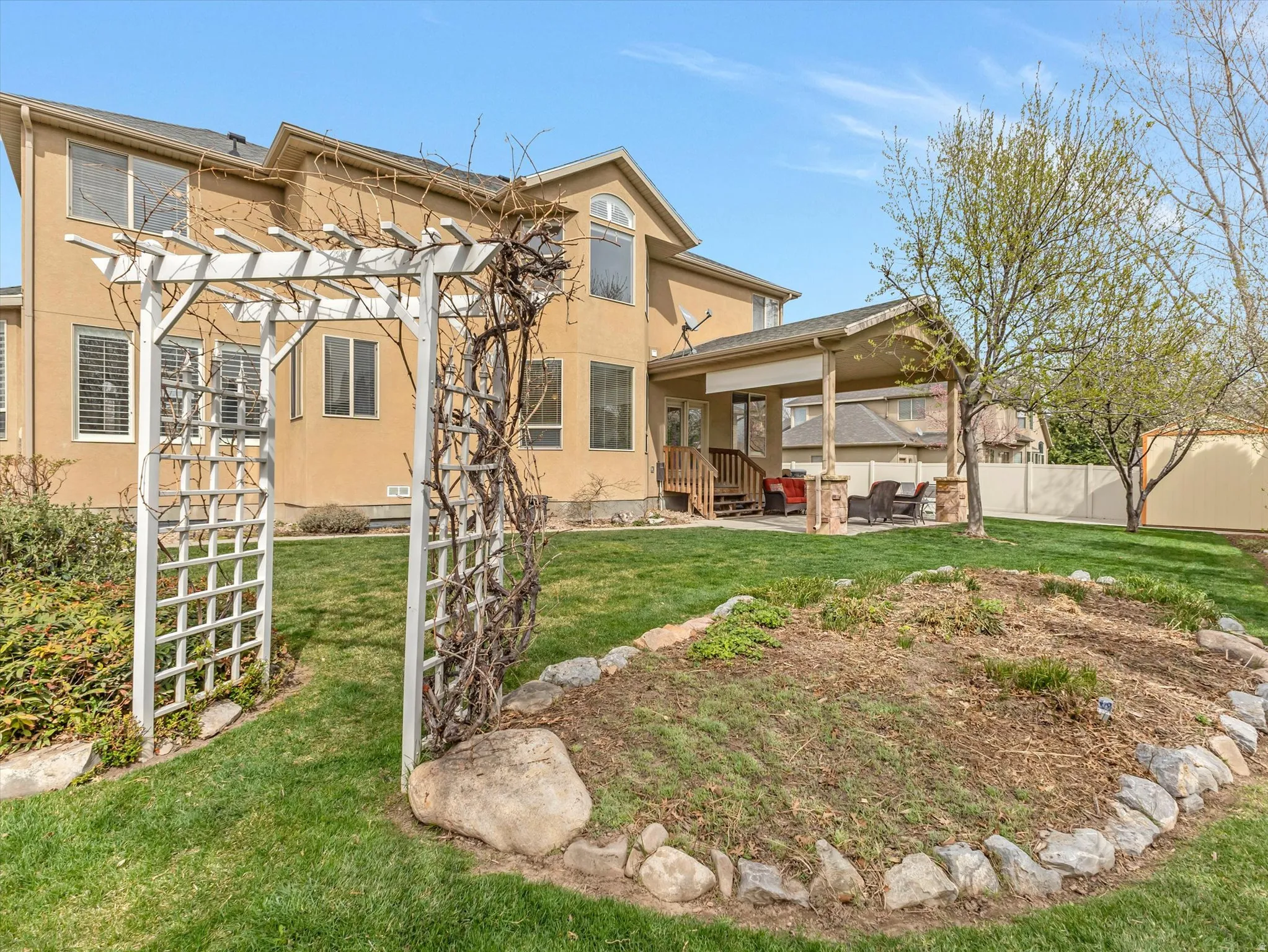 Back of property featuring a patio, stucco siding, a pergola, and an outdoor living space