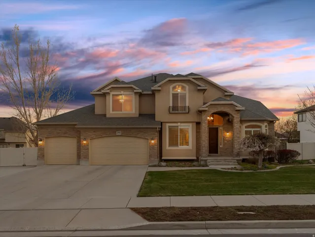 View of front of property featuring concrete driveway, a gate, a garage, a shingled roof, and stucco siding
