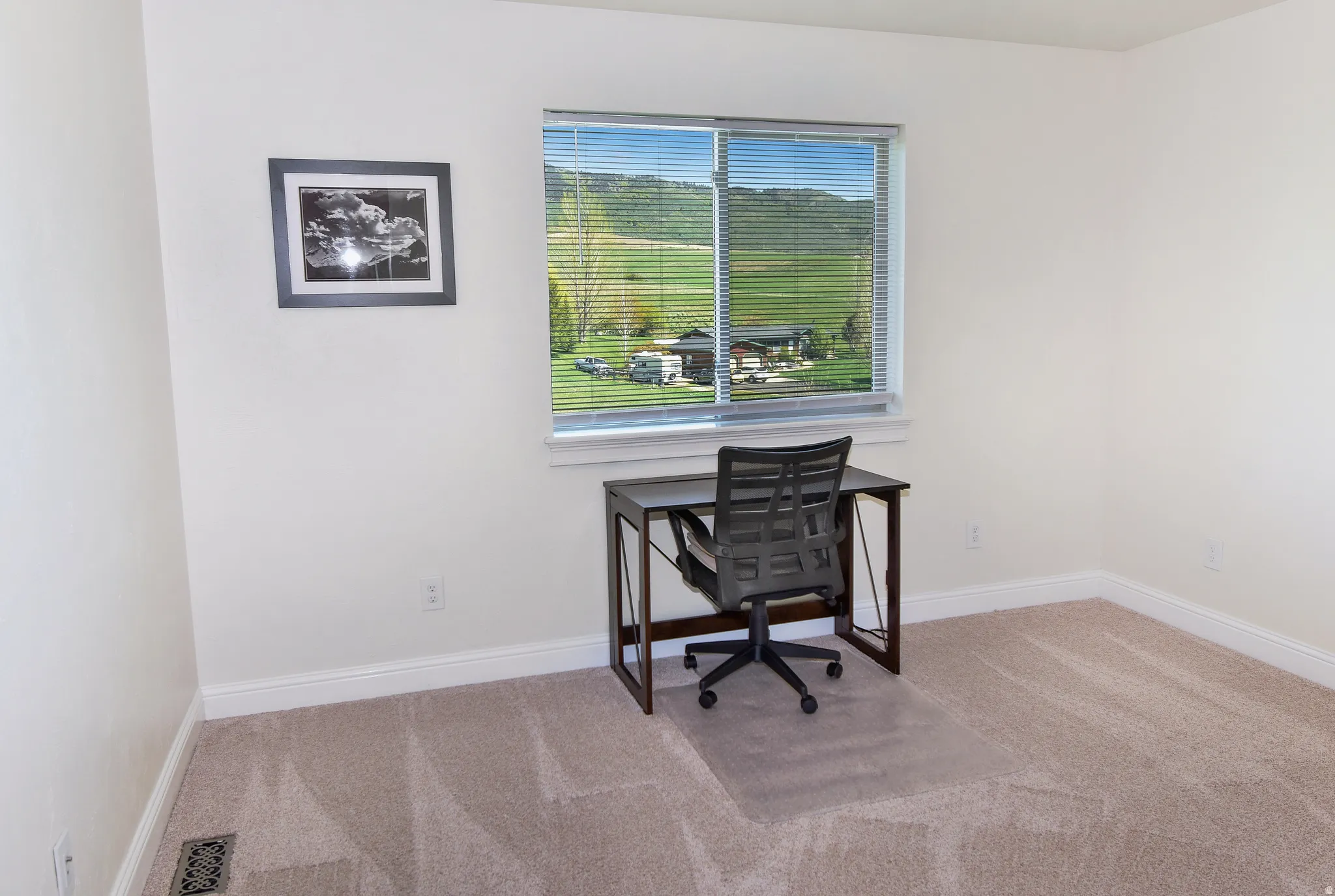 Home office with light colored carpet and baseboards