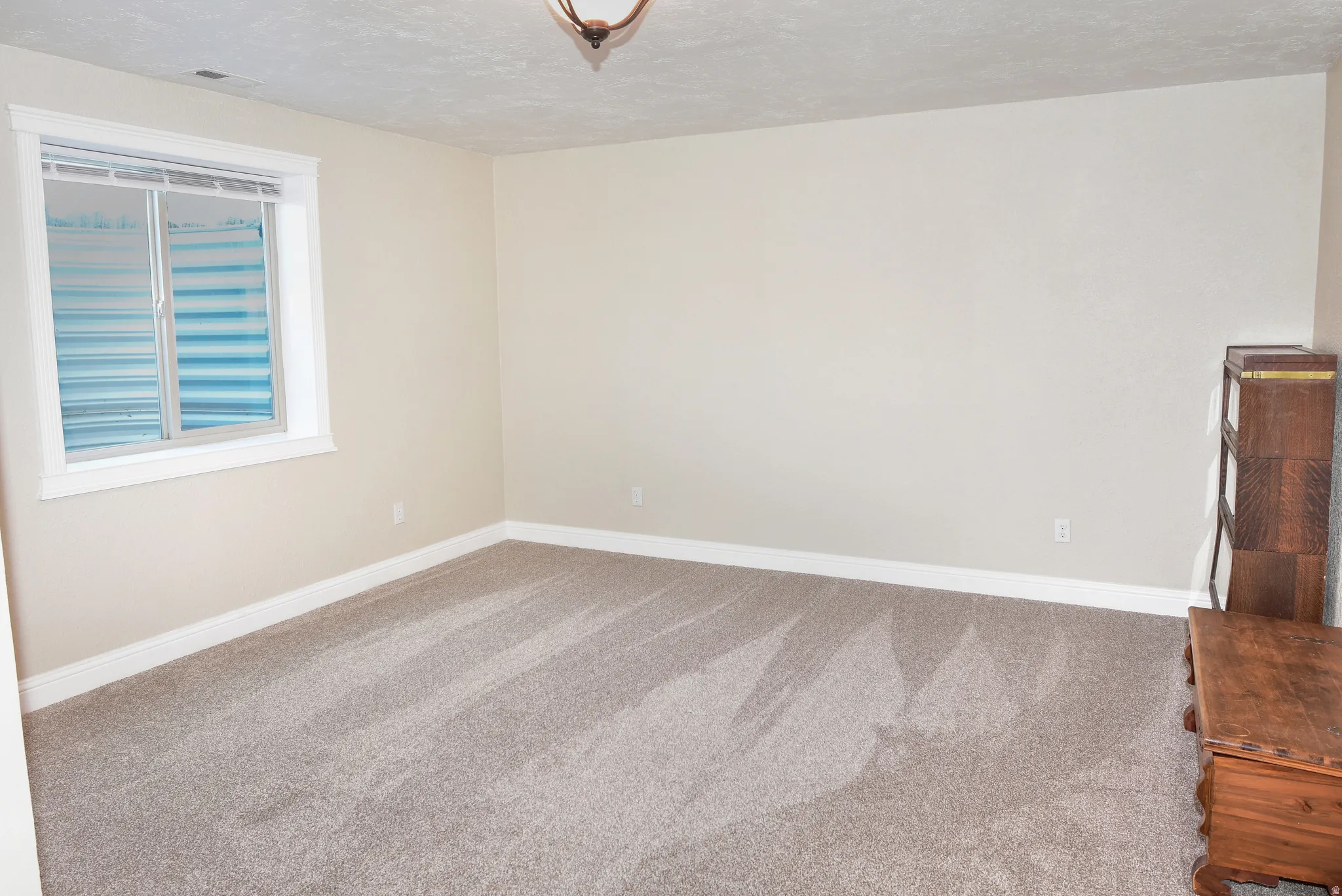 Carpeted spare room with baseboards and a textured ceiling