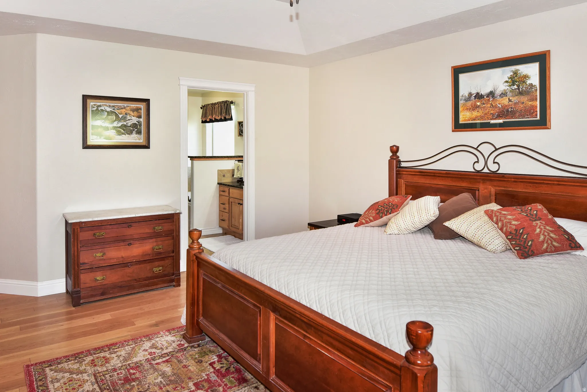 Bedroom featuring light wood finished floors and ensuite bath