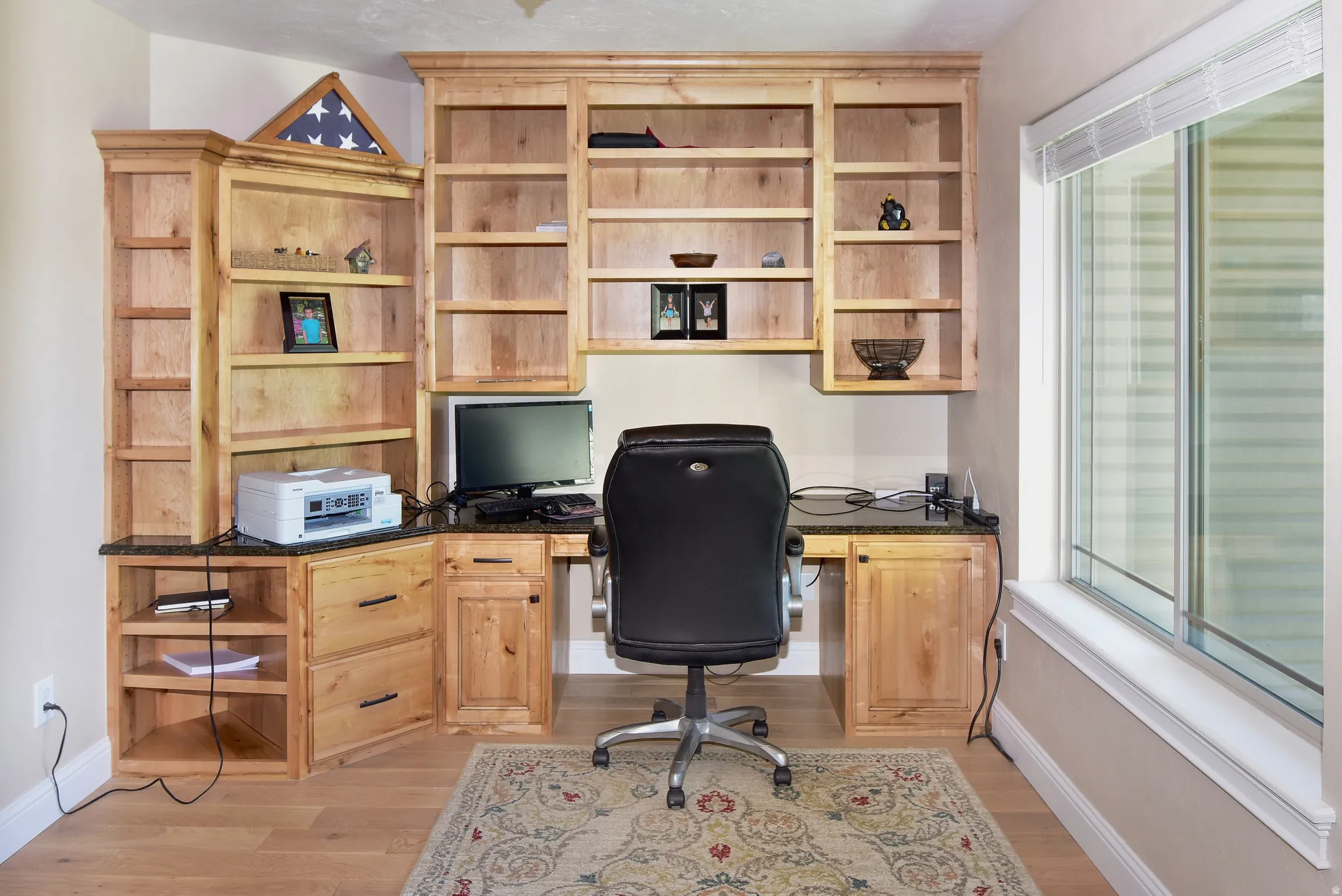 Office space with built in study area and light wood-type flooring