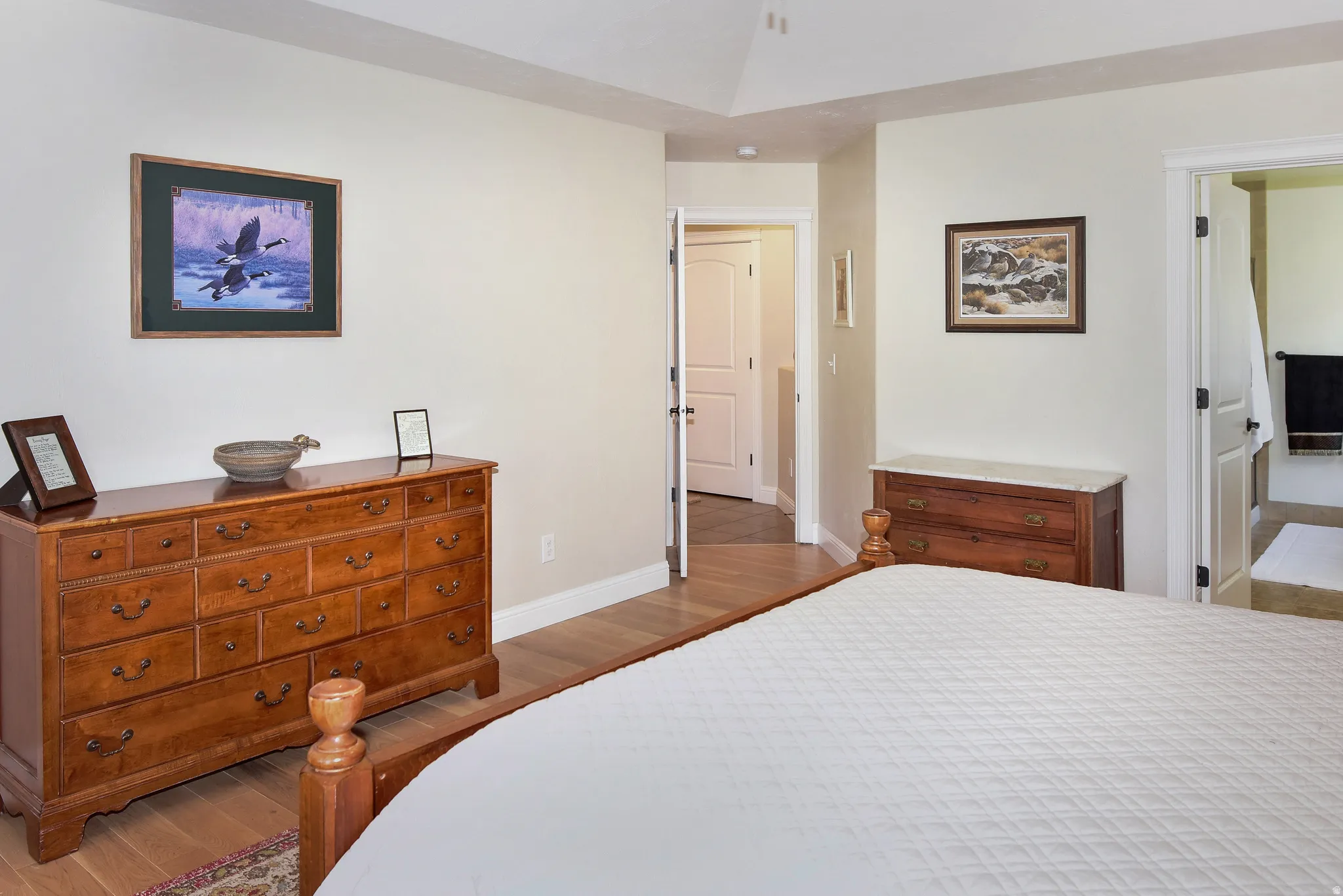 Bedroom with dark wood finished floors and baseboards