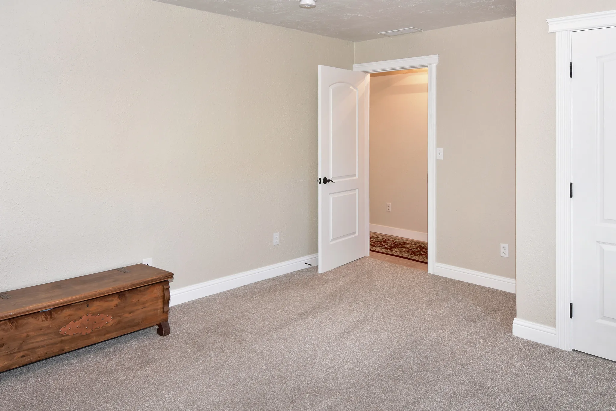 Unfurnished bedroom featuring light colored carpet and baseboards