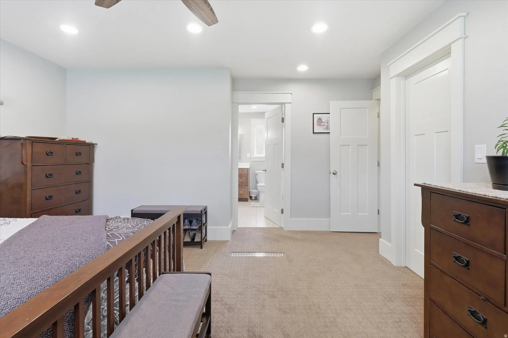 Bedroom featuring light colored carpet, recessed lighting, ceiling fan, and ensuite bathroom