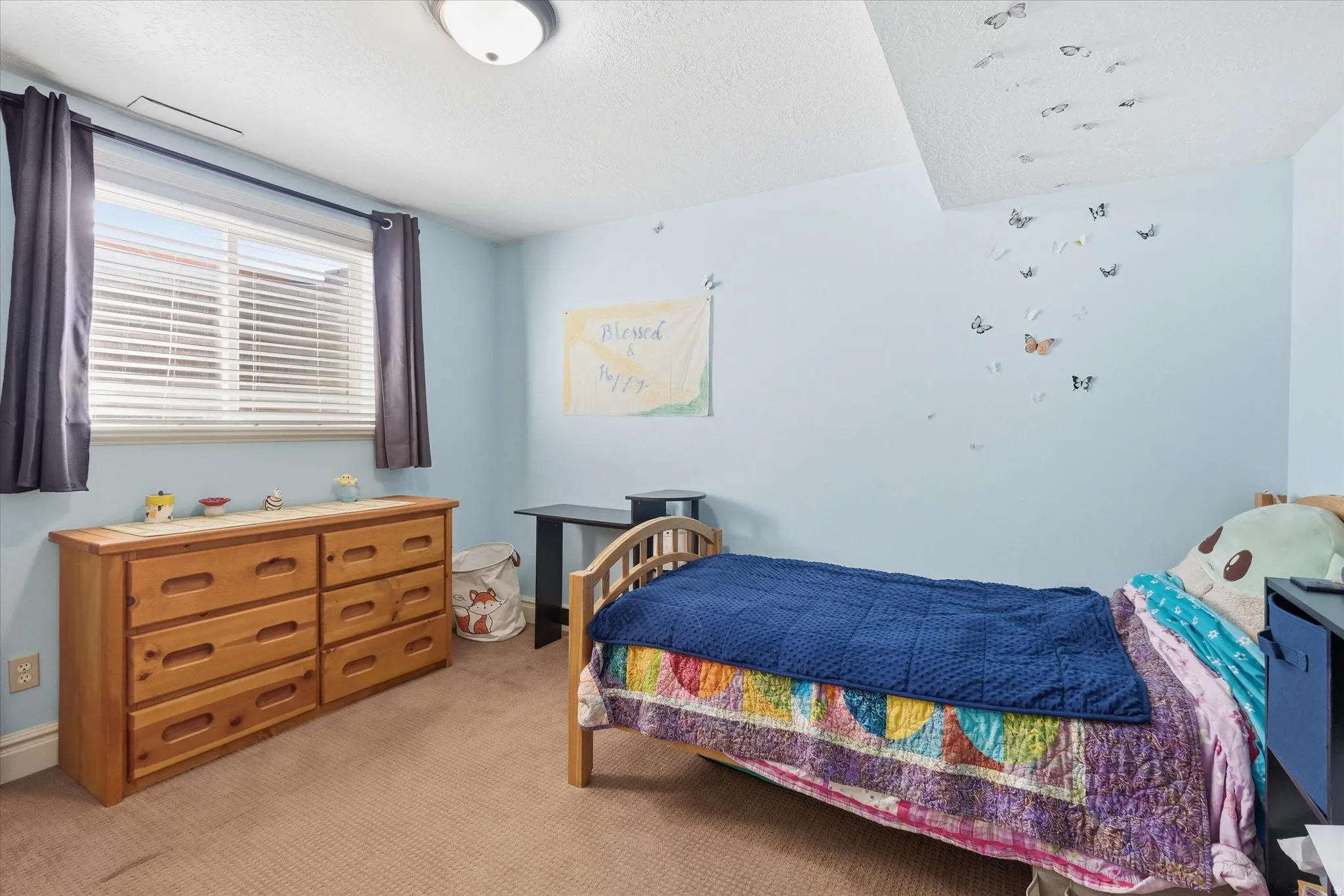 Bedroom with light carpet and a textured ceiling